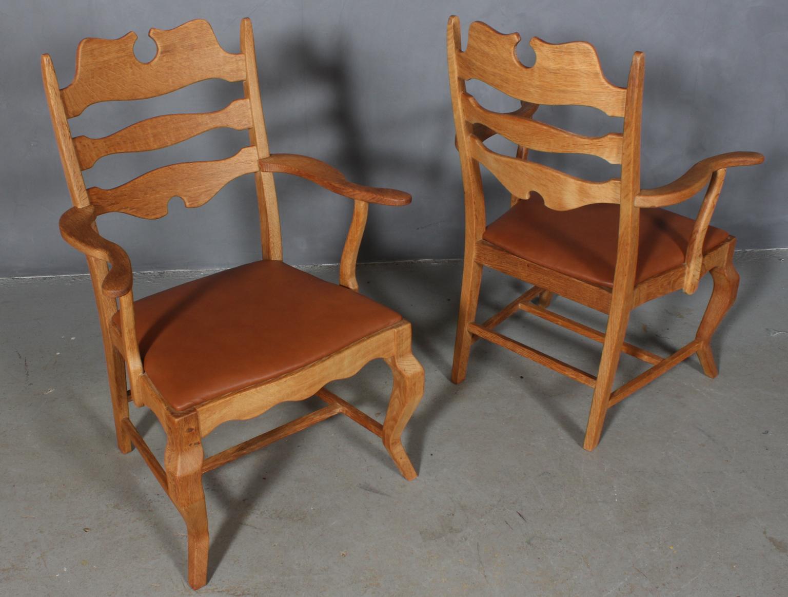 Pair of armchairs by Henning Kjærnulf, made of oak and new upholstered with tan aniline leather. 

Refreshing design with bold Baroque coming together nicely with mid-century modernism.

Model: Razorblade

Made by EG Møbler in the