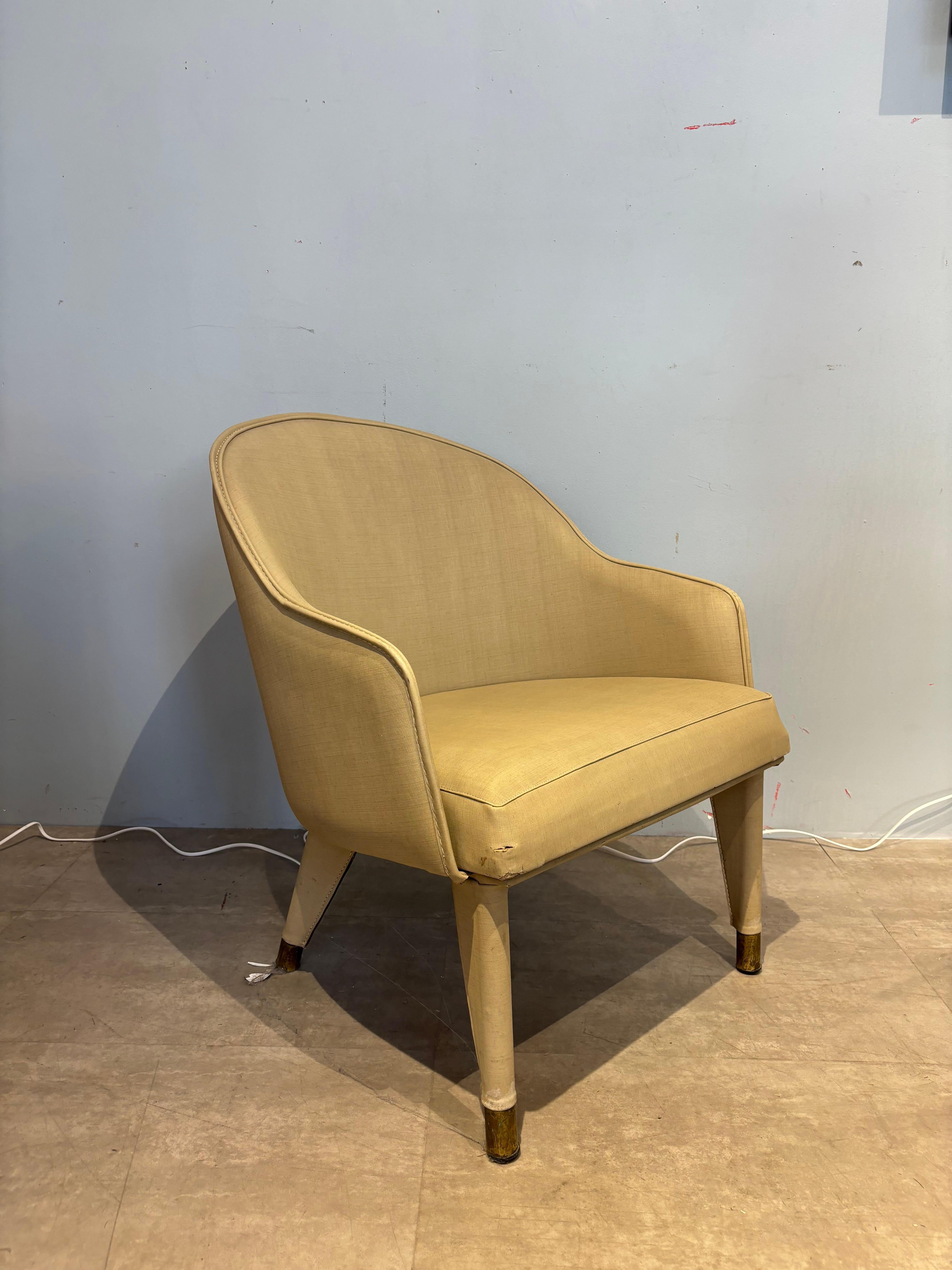 Jolie et rare fauteuil corbeille par Jacques Ad'et en skai blanc et piétement terminé de sabots en laiton. 