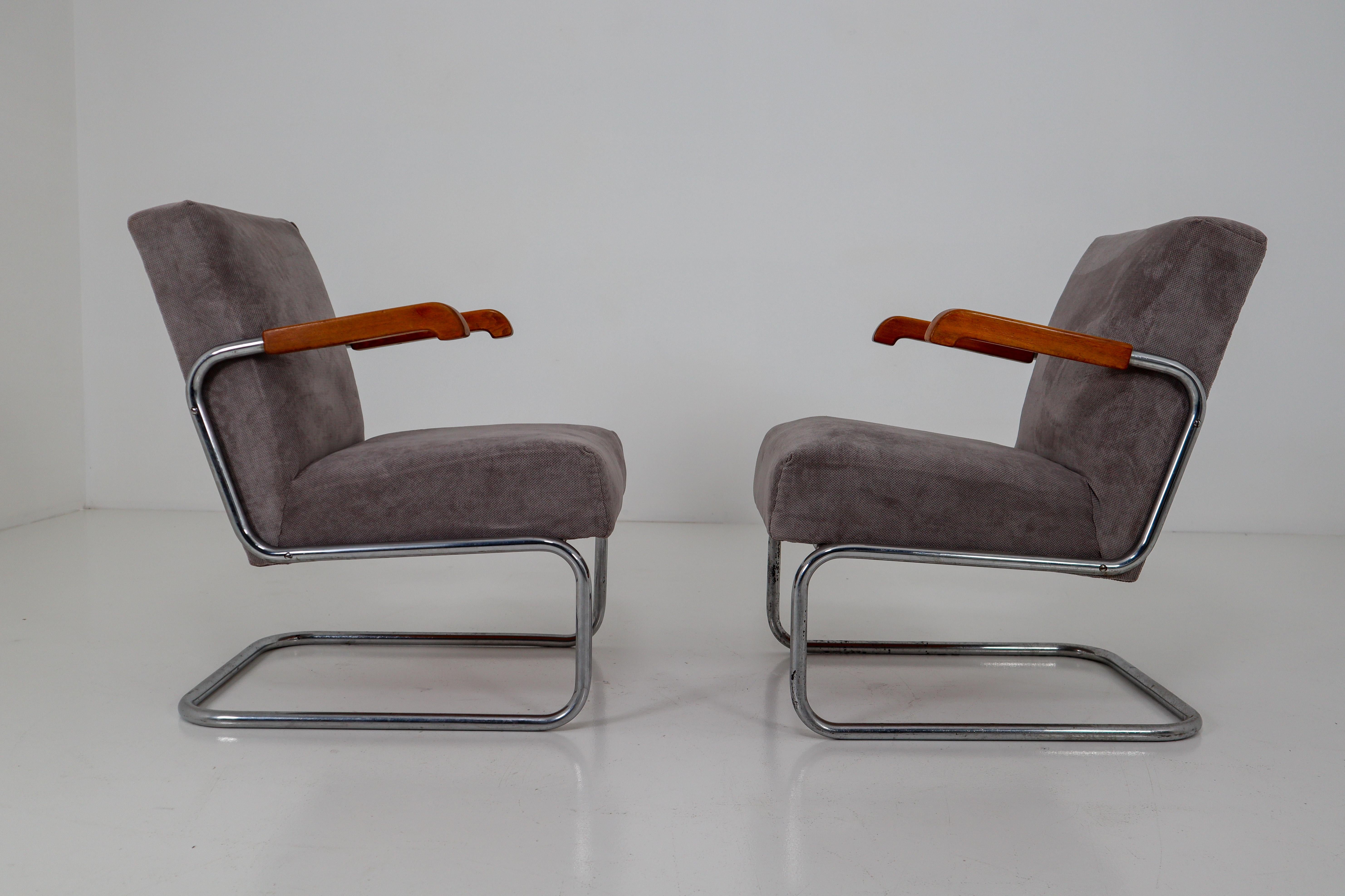 Armchairs by Thonet, circa 1930s midcentury Bauhaus period. These cantilever armchairs are typical for the German and Eastern Europe Bauhaus era. These armchairs has a tubular steel frame and is Re-upholstered with a grey fabric. The original