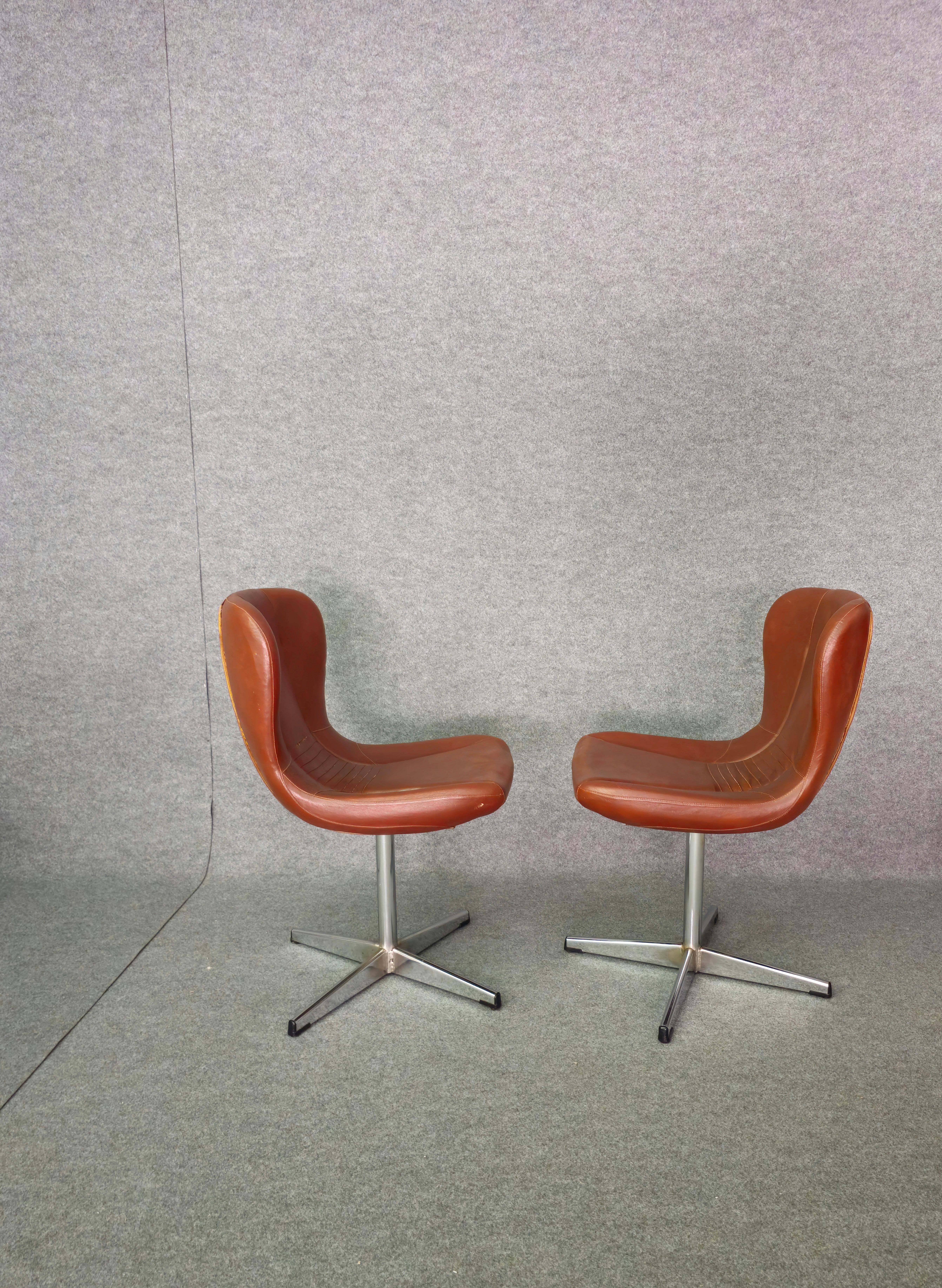 Set of 2 anatomically shaped swivel armchairs/chairs produced in Italy in the 1960s/70s.
Each armchair/chair was made with a wooden structure, quadripod support in chromed metal, curved seat and backrest with leather upholstery in shades of brown.