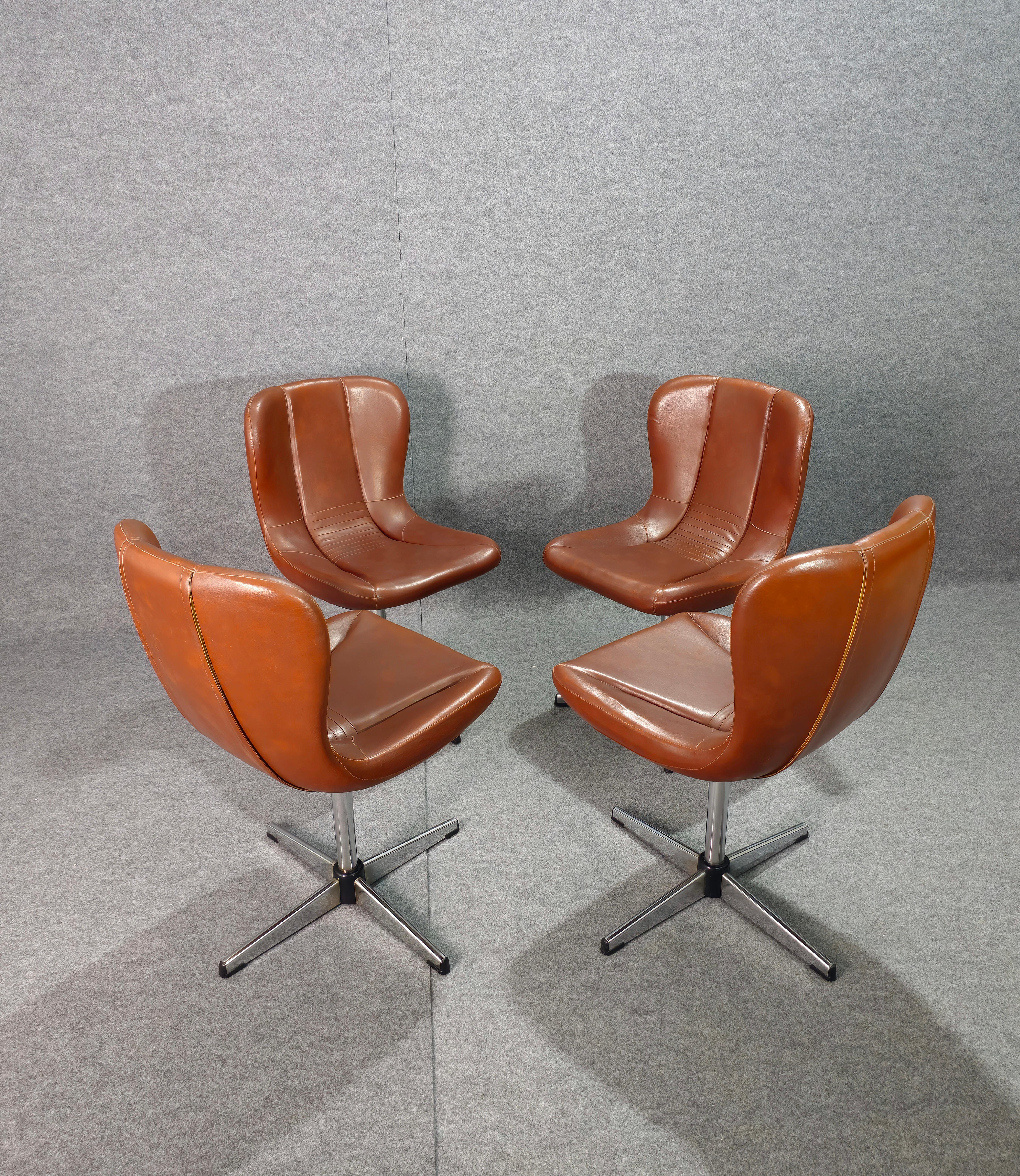 Set of 4 anatomically shaped swivel armchairs/chairs produced in Italy in the 1960s/70s.
Each armchair/chair was made with a wooden structure, quadripod support in chromed metal, curved seat and backrest with leather upholstery in shades of