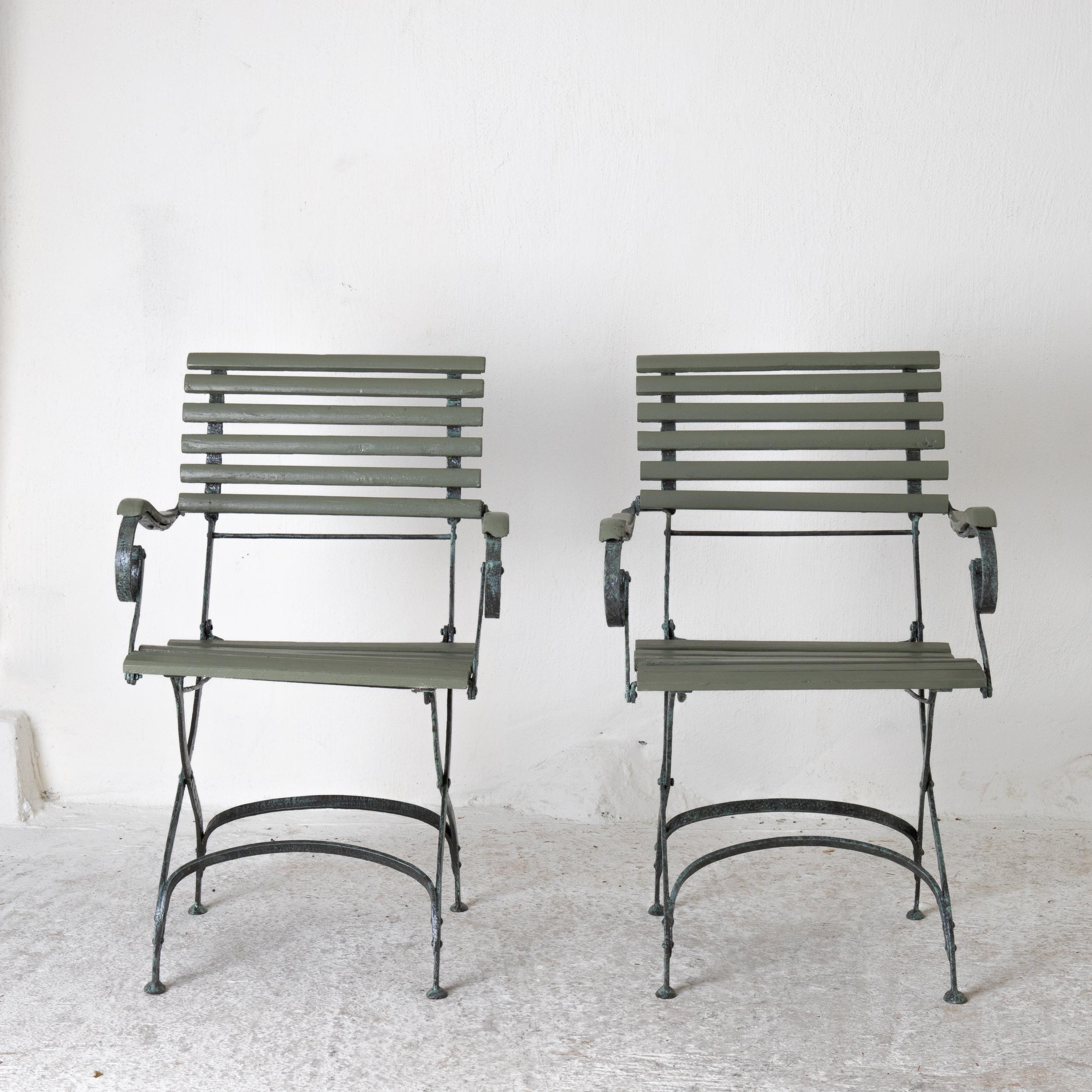 Armchairs garden Swedish green wood and iron, Sweden. A pair of garden armchairs made during the early 20th century in Sweden. Refinished in a muted green with a base made from cast iron. Wooden seat and back as well as armrests.