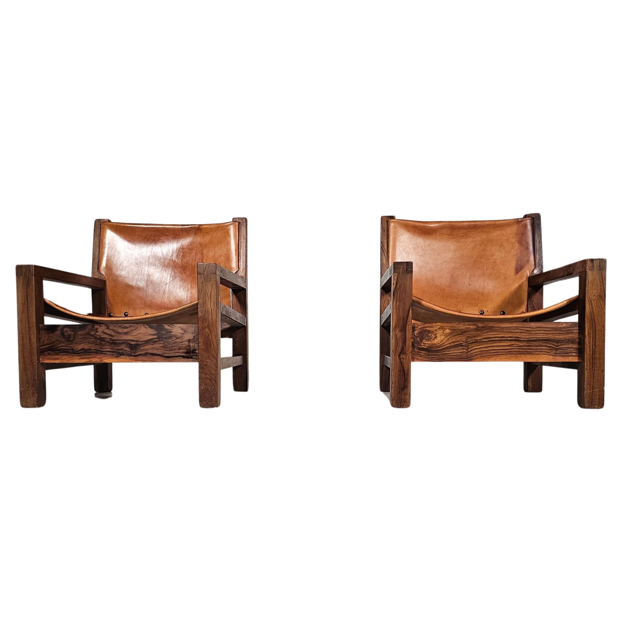 Ein Paar Sessel stammt aus den geschickten Händen eines erfahrenen Tischlers im Frankreich der 1970er Jahre. Die mit viel Liebe zum Detail gefertigten Sessel verfügen über eine Struktur aus edlem Olivenholz, die nicht nur Robustheit, sondern auch
