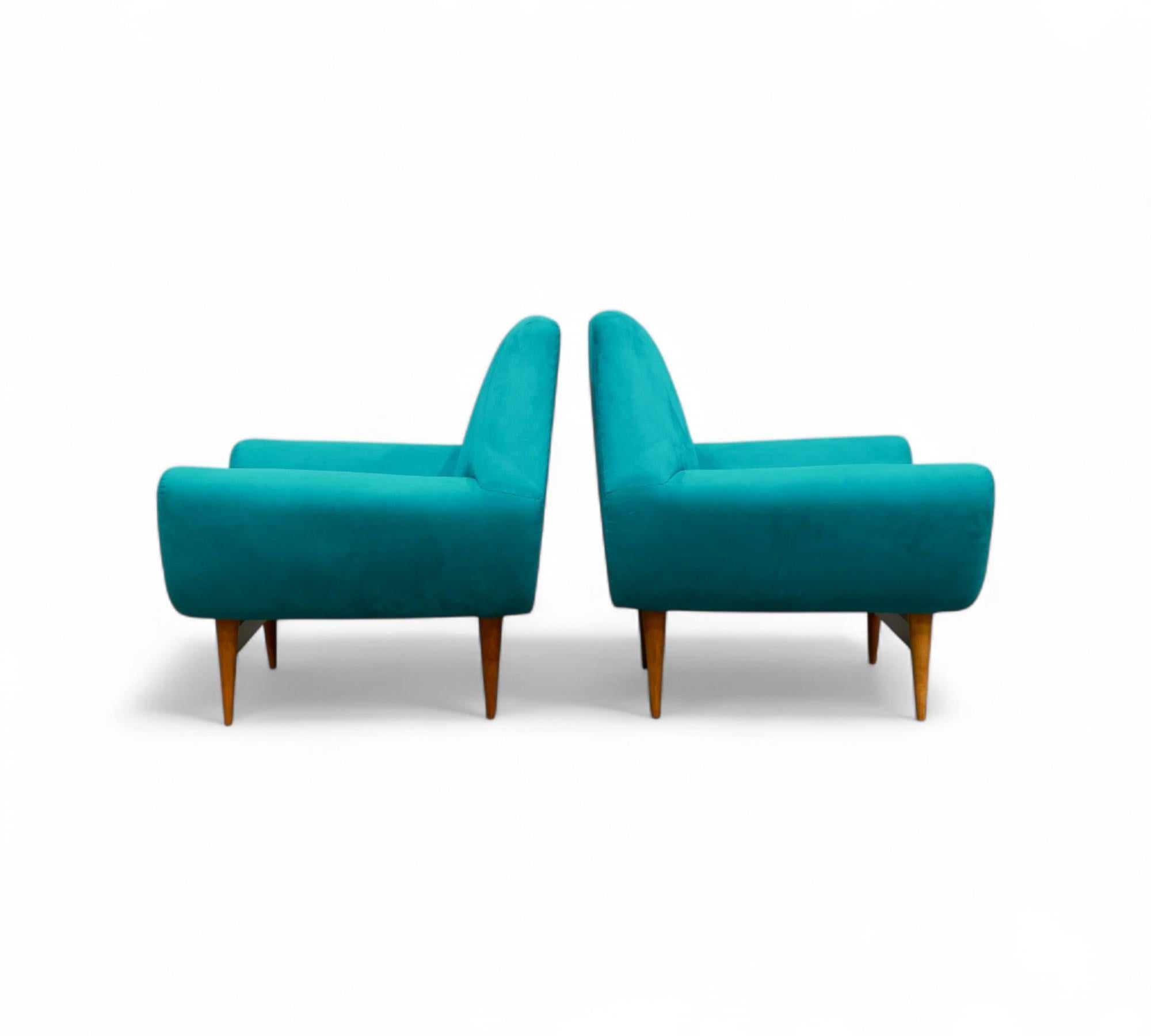 These striking armchairs showcase a sturdy frame constructed from high-quality hardwood, complemented by an eye-catching turquoise fabric upholstery. The body of each armchair boasts elegantly curved backrests and armrests, as well as delicate