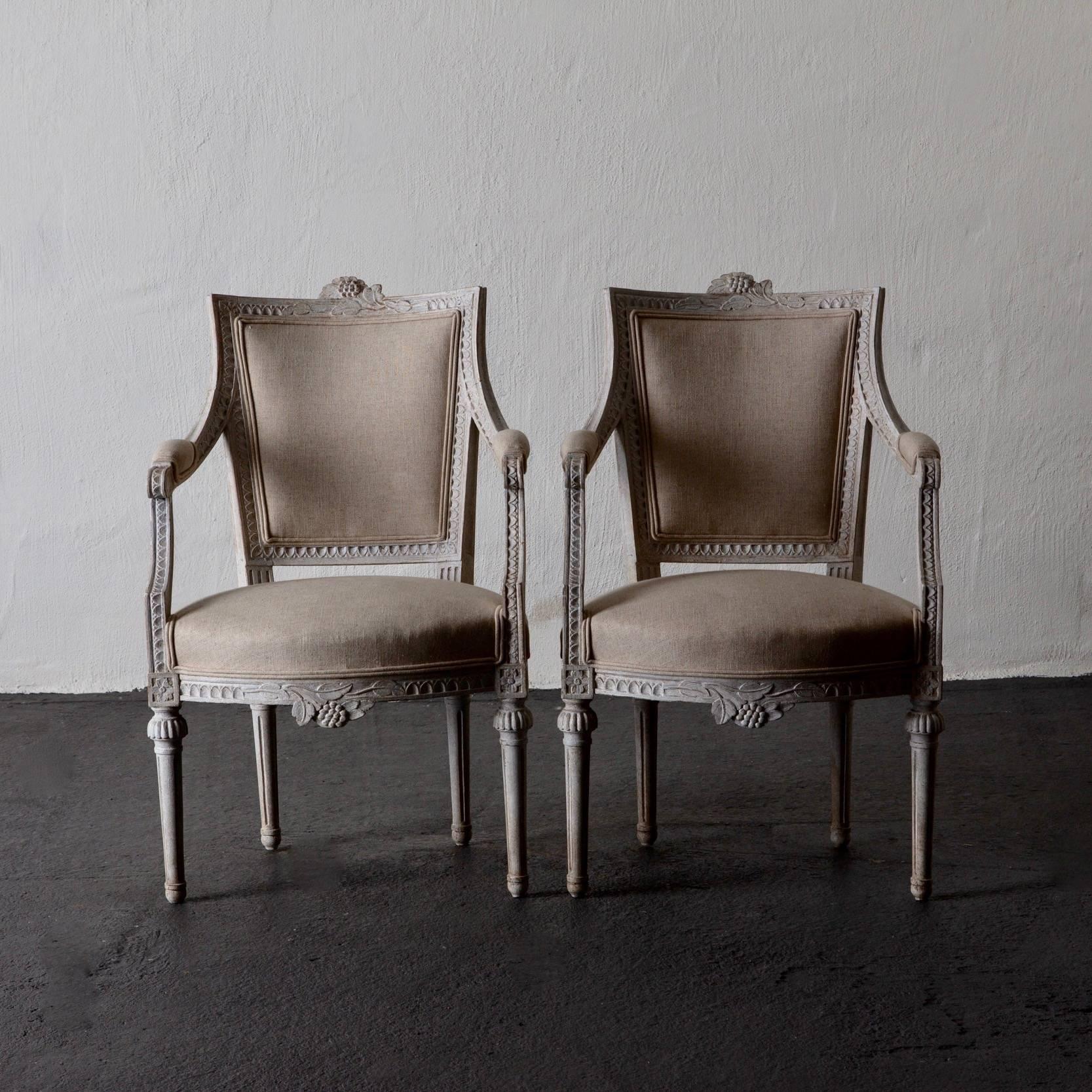 Armchairs pair of Gustavian 19th century Swedish white Sweden. A pair of armchairs made during the Gustavian period in Sweden. Frame in white washed finished with nail tip carvings and flowers. Legs are rounded and channelled. Seat, back and