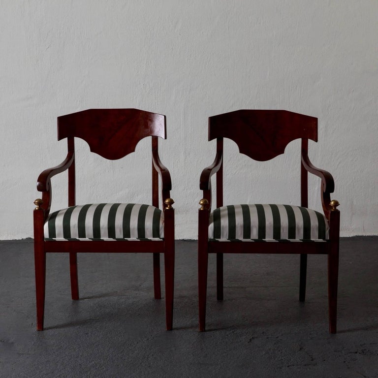 A pair of armchairs made in Sweden during the Karl Johan period 1810-1840. Frame made in mahogany with gilded details. Upholstered in a durable outdoor Rogers and Goffigon stripe.

 