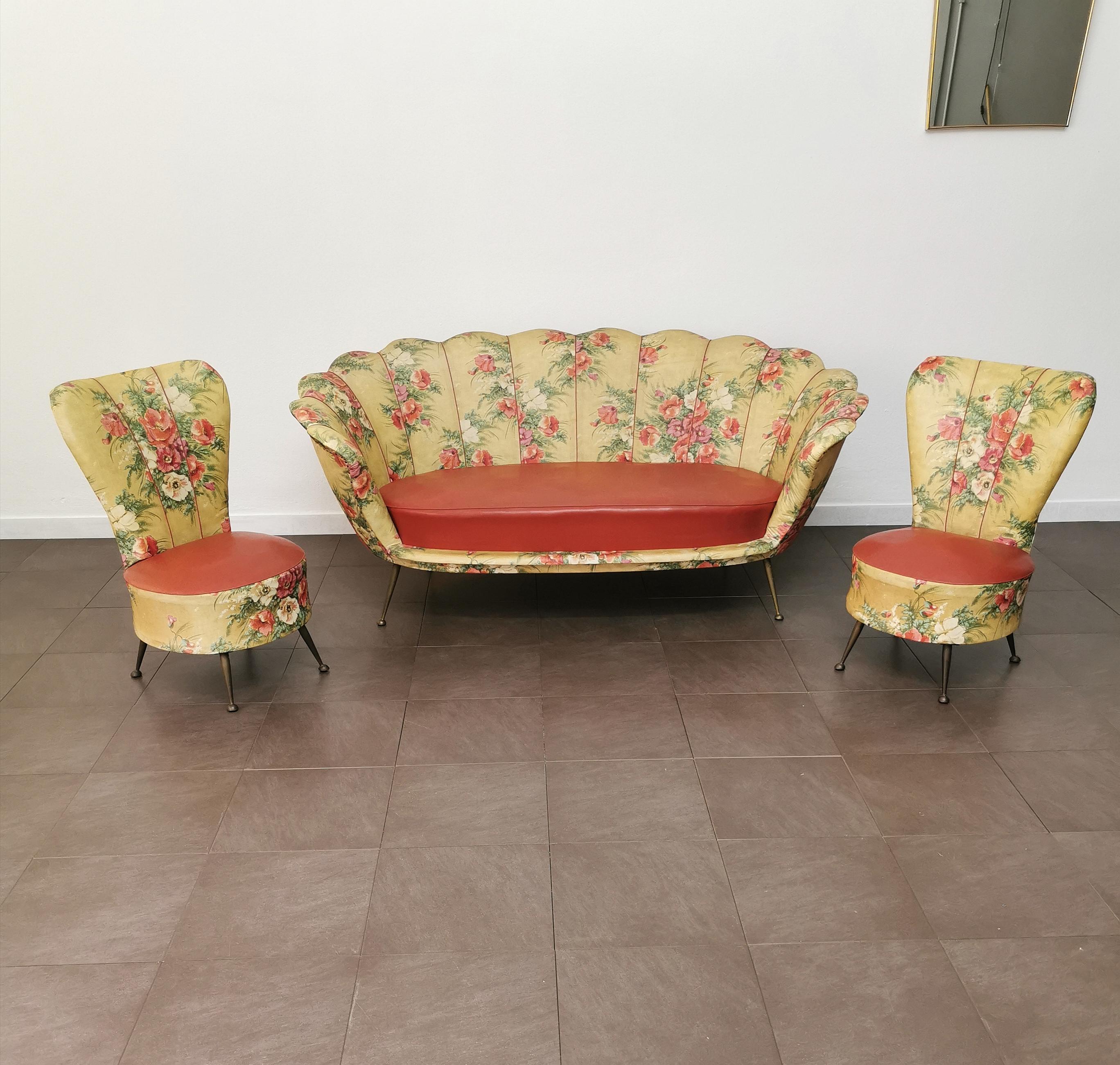Set of 2 small living room armchairs and 1 sofa made in Italy in the 1950s. The set was made with a synthetic oilcloth cover with floral pattern, seat in red eco-leather and 4 brass pin feet.