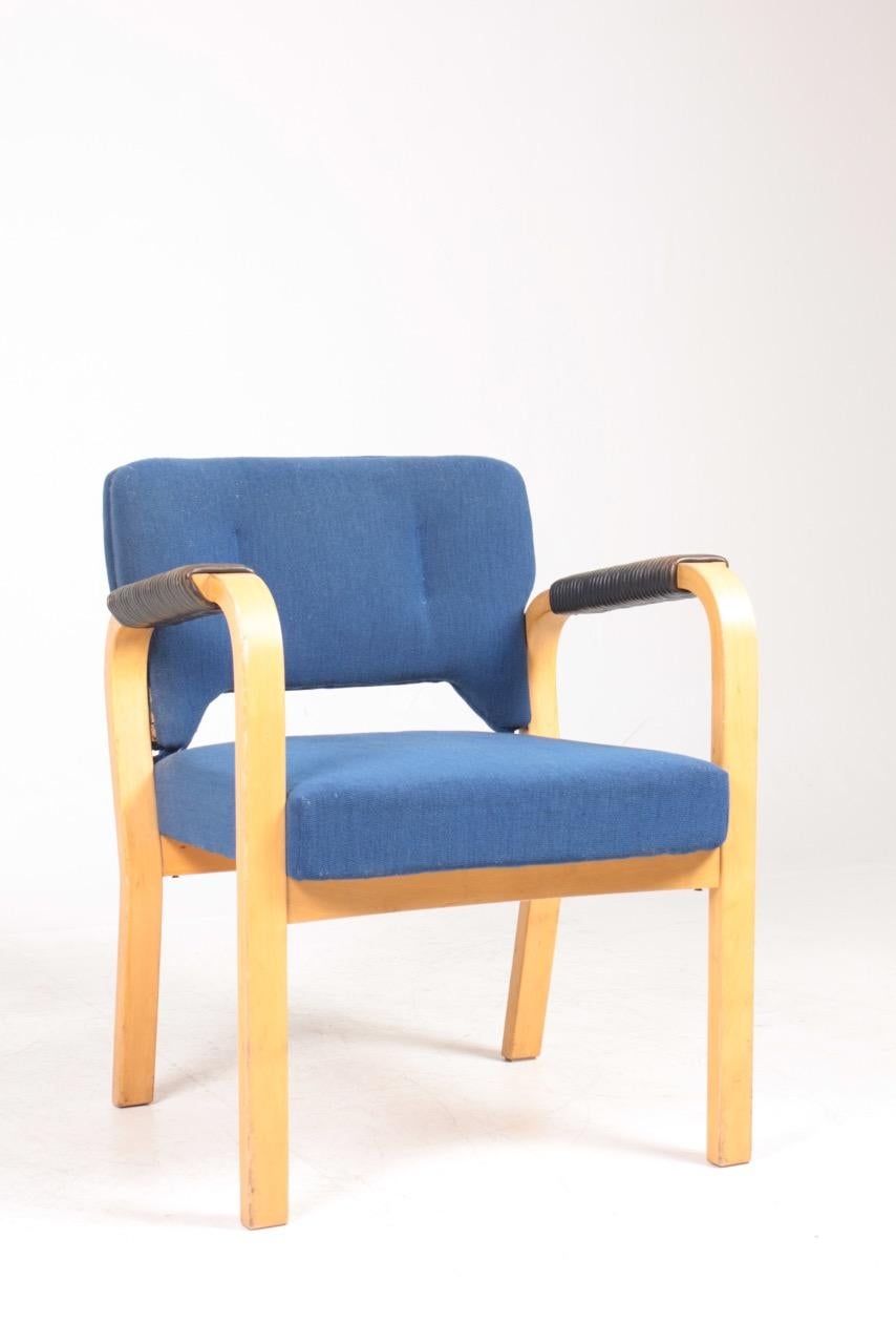 Armchairs with fabric and patinated leather arms. Designed by Bymaija Heikinheimo for Artek.