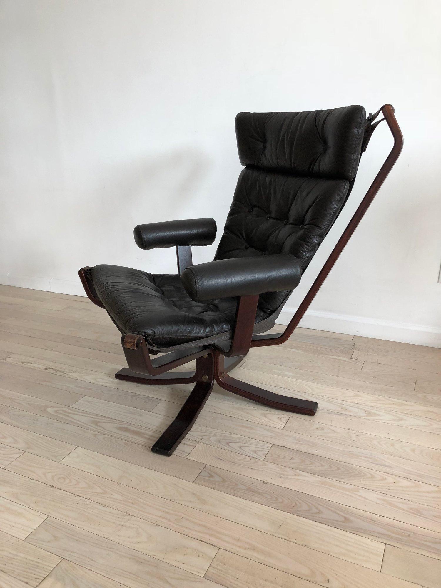 Armed 1960s rosewood and leather falcon style chair after Sigurd Ressell made in Norway. Ultra comfortable, the chair you never want to get out of. Perfect vintage condition. Zipper attached leather cushions and leather straps. 

Measures: 31” wide