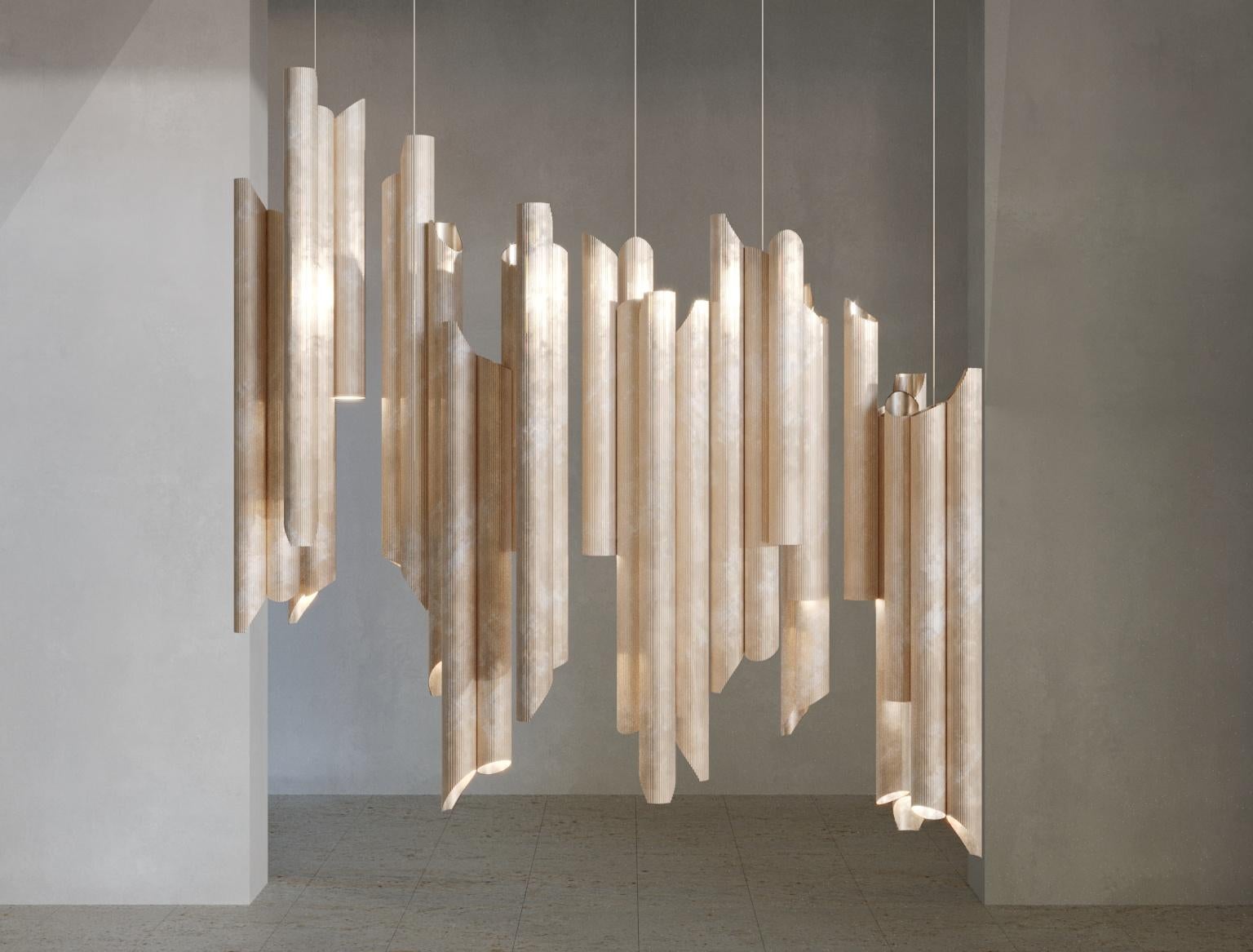 Armilla chandelier by Scattered Disc Objects 
Dimensions: D 120 x W 50 x H 50 cm 
Material: brass striped pipes, aluminum, Led spot light, steel cables.

Armilla invites to a relationship with light. The tubes, like Doric columns, call for a