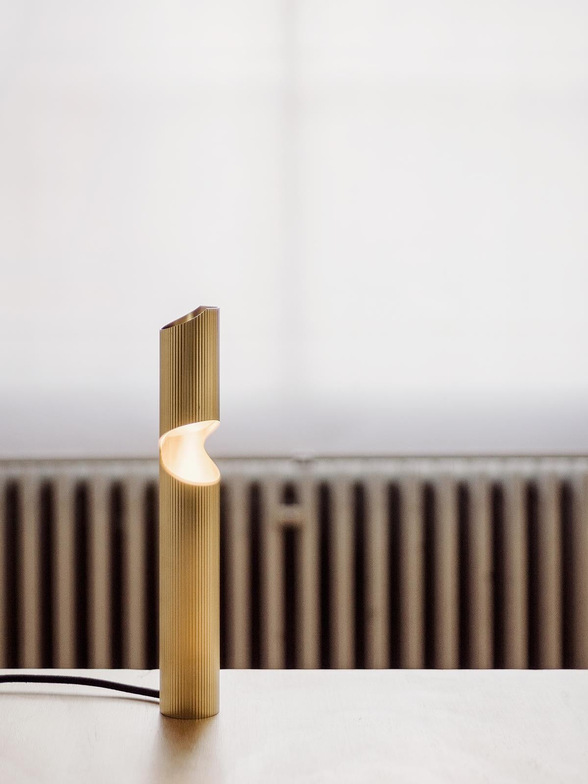 Armilla Table Lamp by Scattered Disc Objects
Dimensions: Ø 5 x H 33.5 cm. 
Materials: brass striped pipes, brass mirror, aluminum, LED spot light.
Driver: 12V 12W 1A, IP67.
Light source: 1x 4.2W Led GU4 MR11 Spot 2700K 345 lumen, replaceable.
Cable: