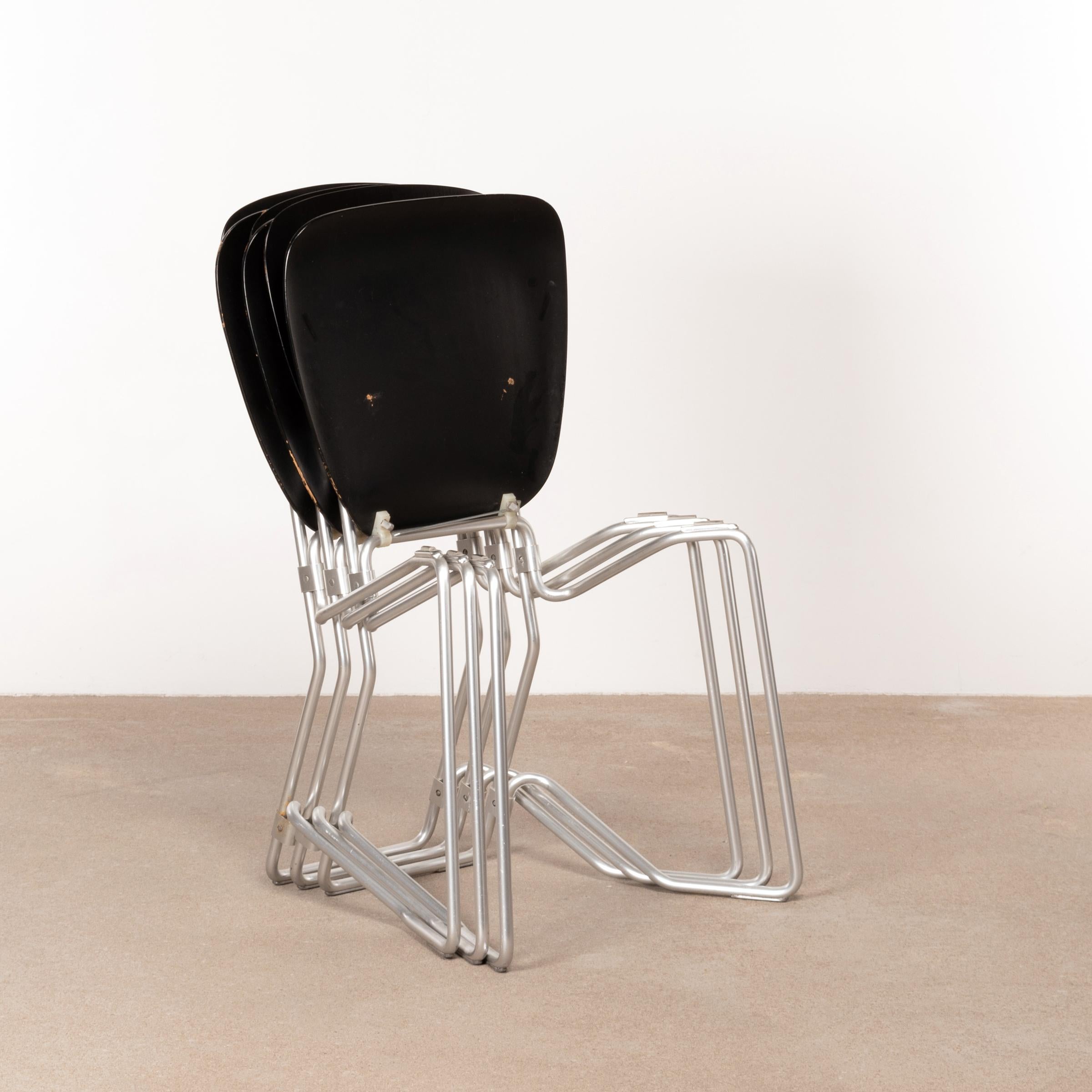 Armin Wirth folding / stacking chair for Aluflex Switzerland designed in 1951. Early production with a smart constructed lightweight frame of aluminum and black dyed plywood seats all in good original condition with traces of use.