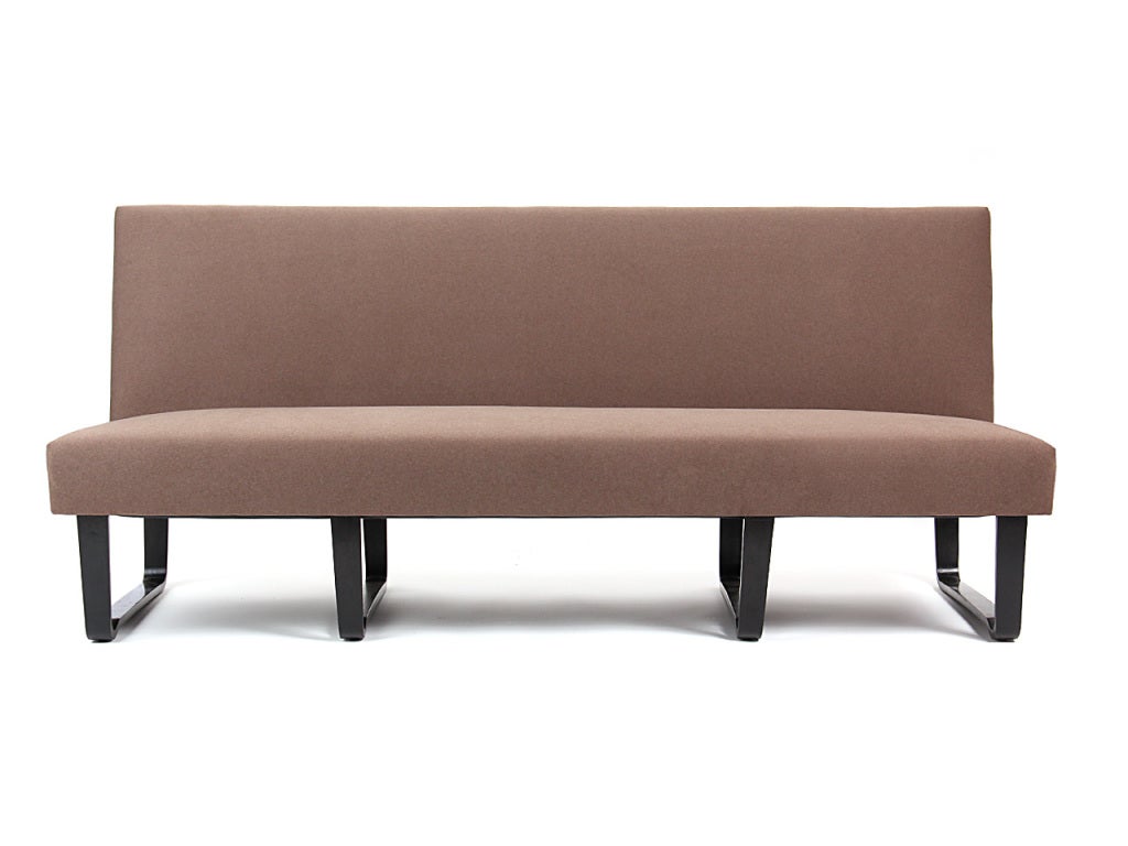 An armless sofa or bench or banquet on laminated mahogany 