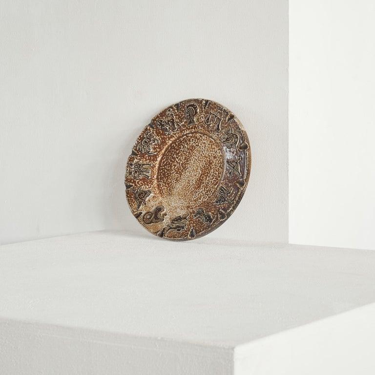 ArmogrÃ¨s Belgian 'Zodiac' Studio Pottery Dish in dark tones. Belgium, 1960s.    Beautiful and large 'Zodiac' themed studio pottery dish by ArmogrÃ¨s, one of the famous pottery workshops near Charleroi in Belgium. Large and sturdy, this dish is a