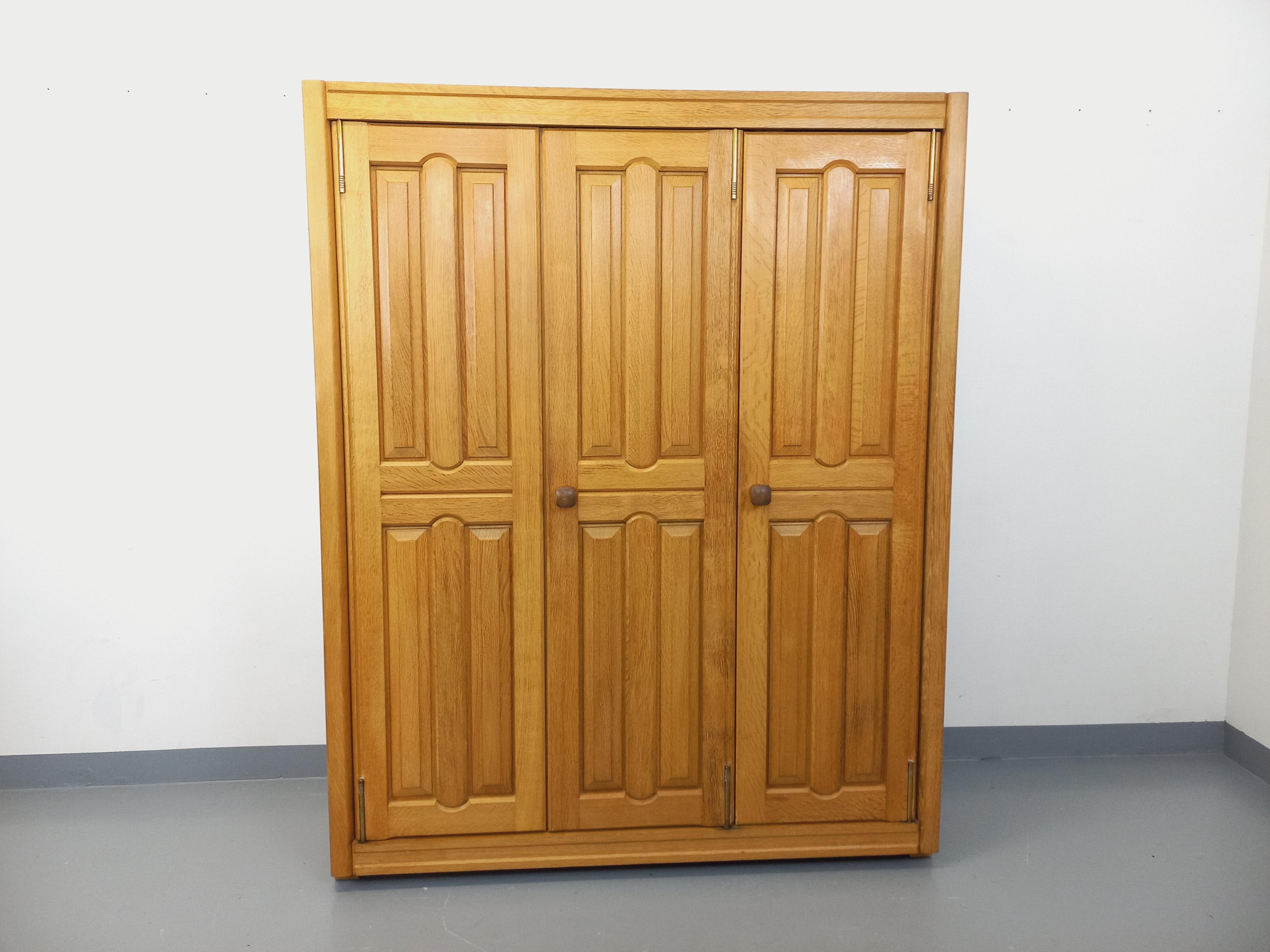 Armoire dressing vintage degli anni '60, di Robert Guillerme et Chambron per l'editore Votre Maison, superbo nella concezione e nel design con un ingegnoso sistema di ante girevoli, in bois de chêne clair massif brutaliste, 3 porte, 1 parte penderie