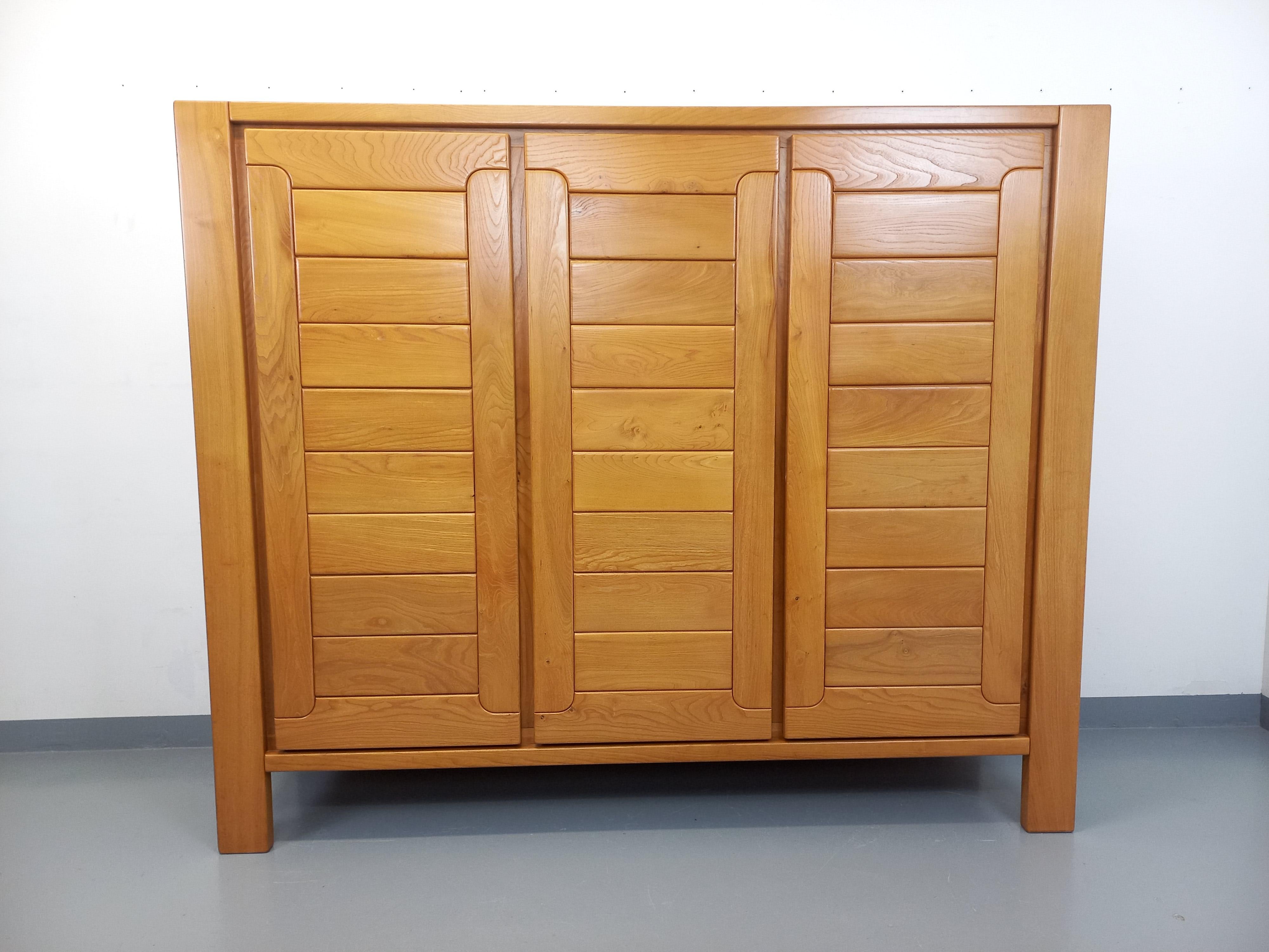 Superbe und seltene Kleiderschrank vintage des années 70 80, Maison Regain, en magnifique orme blond, très beau design. 3 Portes, beaucoup de rangements : 1 penderie, 6 étagères, 1 tiroir intérieur. Très bon état général avec quelques signes du