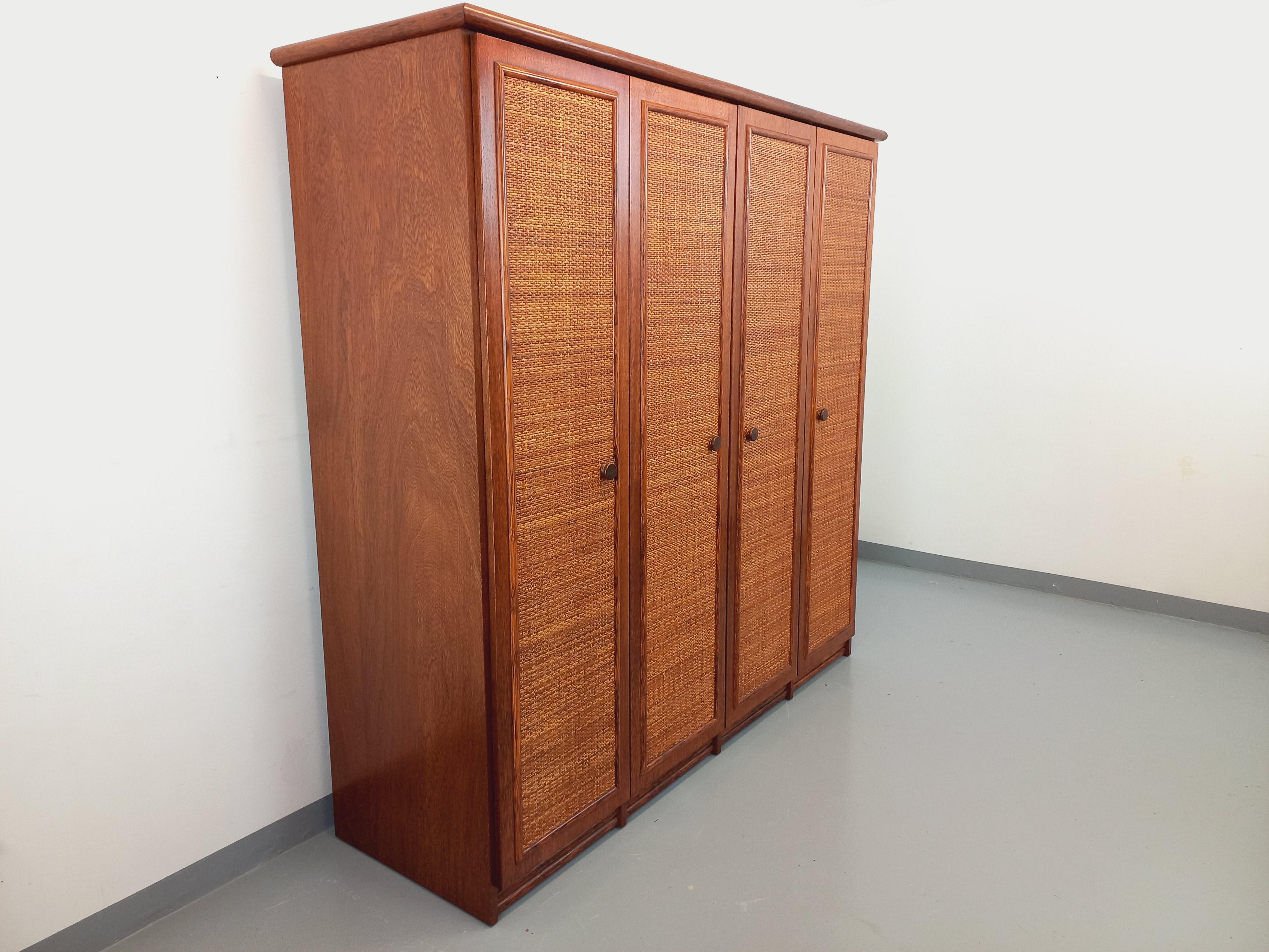 Armoire vintage des années 70, marque Maugrion éditée par Roche-Bobois, en rotin, rotin tressé et bois, poignées rondes et plates, 3 parties penderie avec étagère supérieure, 1 partie avec 4 étagères, très belle qualité, idéal pour dressing et