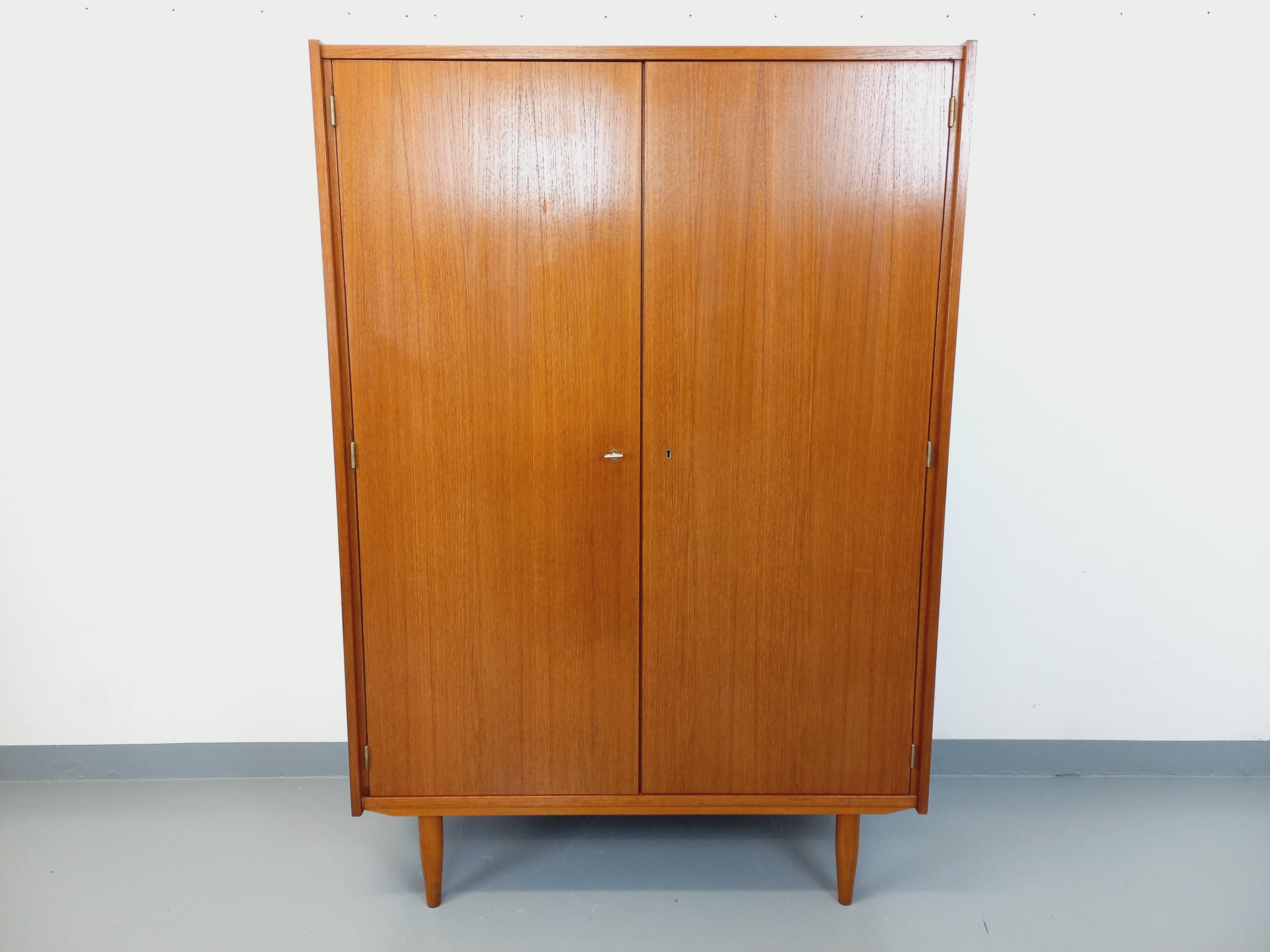 Armoire vintage style scandinave des années 60, en teck, pieds compas, beaux rangements : 2 portes avec une partie penderie avec étagère et une partie avec 3 étagères, 1 clé pour les 2 serrures, très bon état général.
Réf 250 126
Hauteur : 173