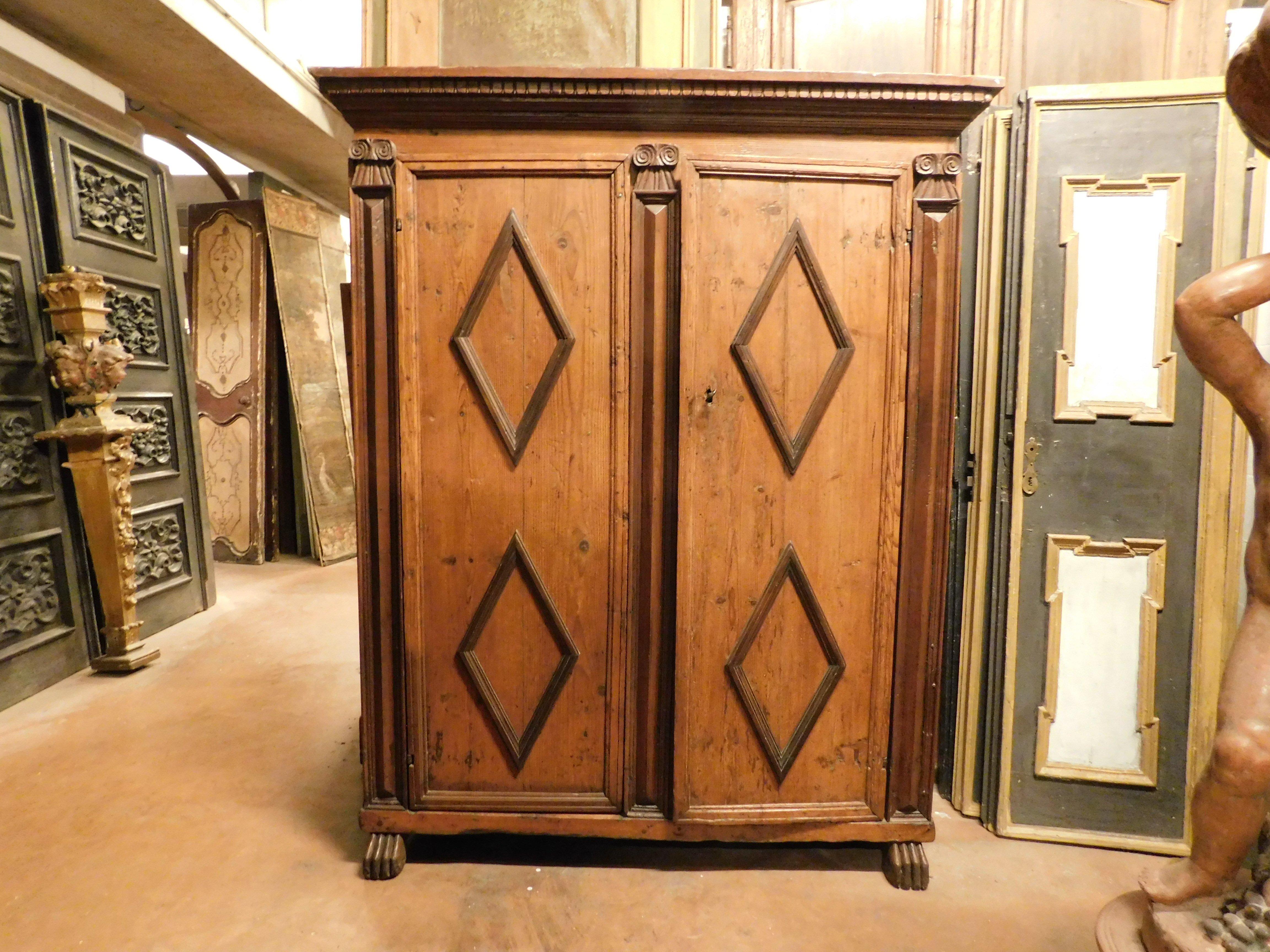 Antique Wardrobe, solid larch wood furniture, carved with two doors with rhombuses and lion feet, carved side columns, in beautiful patina, original from the 17th century and from Italy. very large and in good condition, unique and beautiful