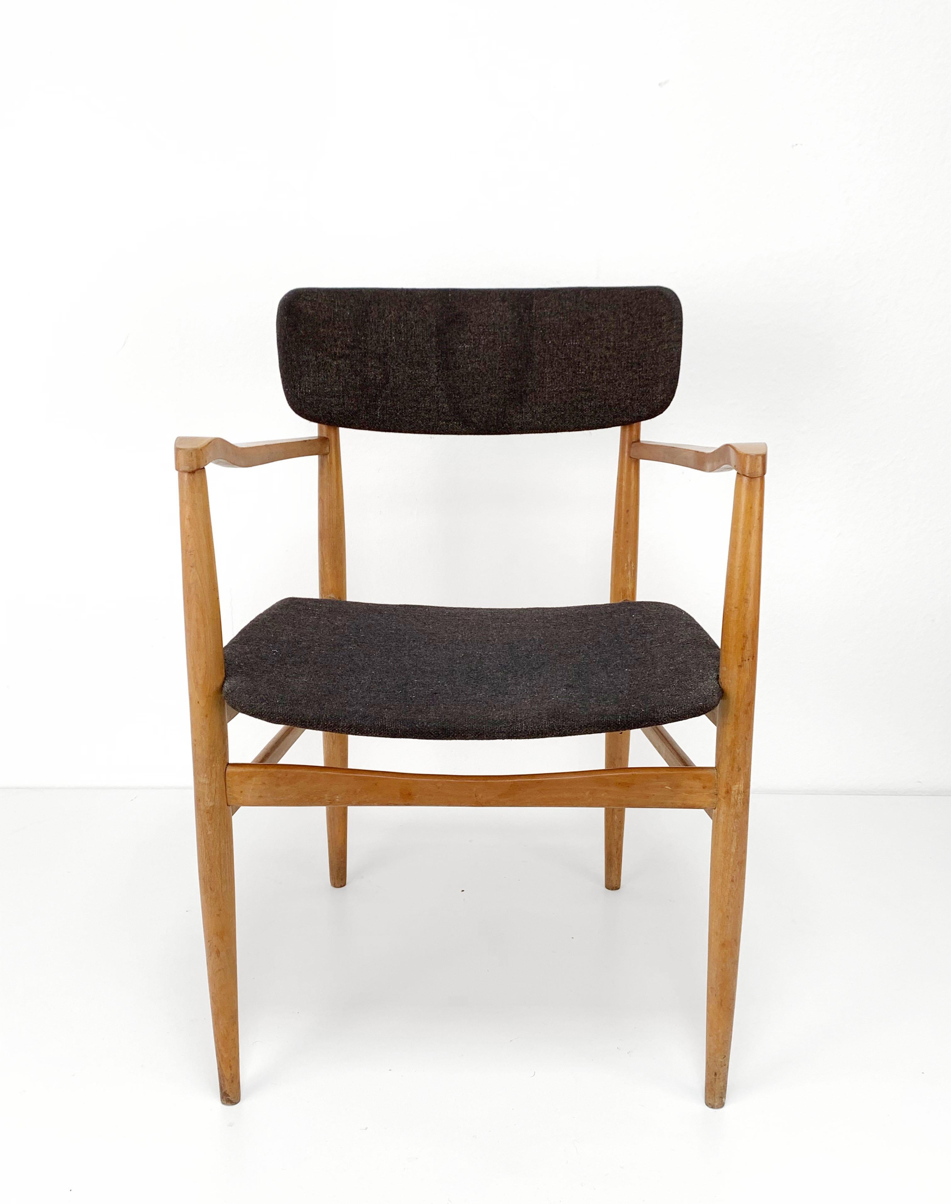 A comfortable chair with armrests and a beautifully curved back, in the style of Finn Juhl. The chair is made of light wood with fabric covering. The chair is in good vintage condition and would be perfect to use in combination with a desk.