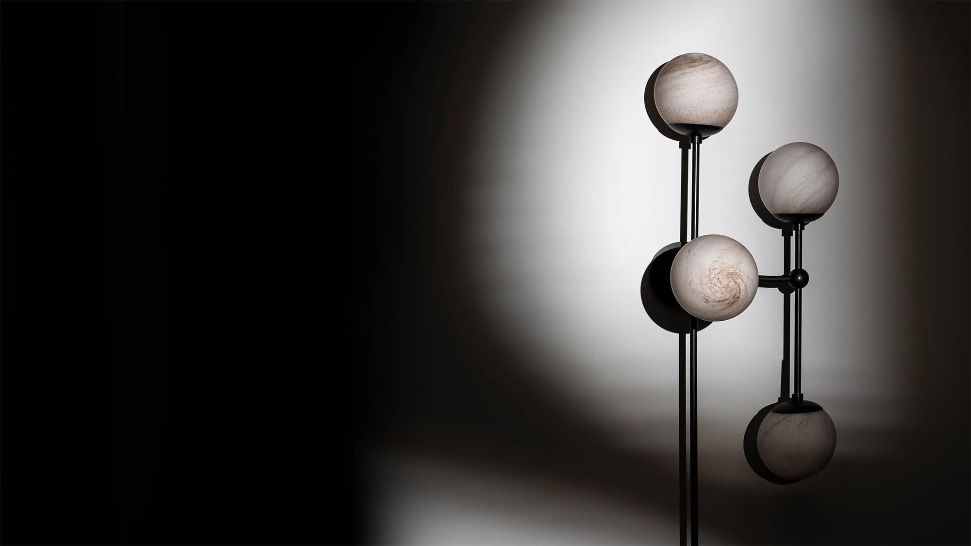 Armstrong 6 captures a sense of movement. Forms connect with spontaneous energy, punctuated by glass spheres. Linear elements complement the carefully crafted brass, echoing a reinforced internal skeleton. The flush mount base gives this lamp