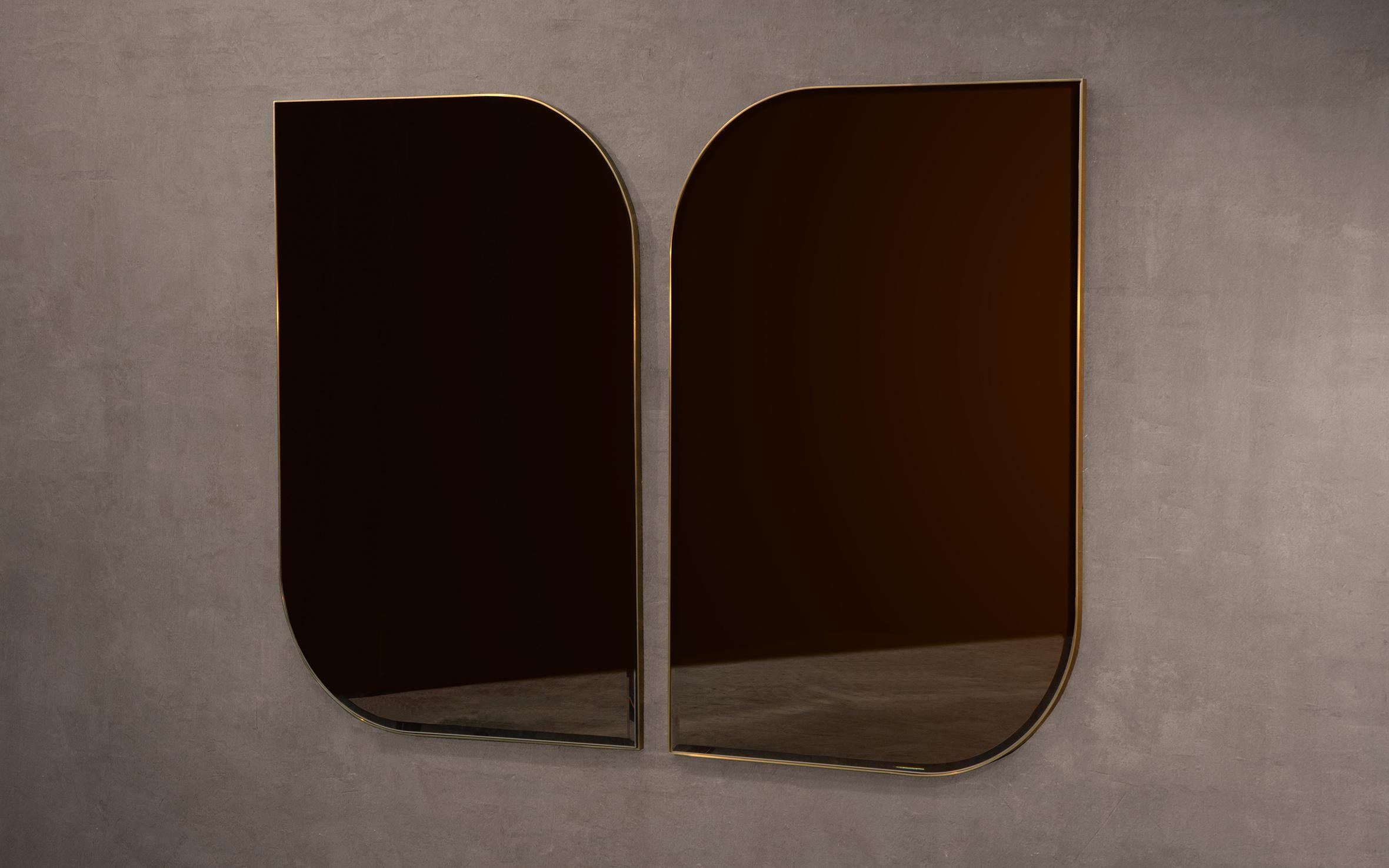 Ein handgefertigter Wandspiegel aus poliertem Messing und geschliffenem, bronzefarben getöntem Glas. Erhältlich als Links- und Rechtshändervariante für die Möglichkeit, zwei miteinander zu koppeln.

Kann sowohl im Hoch- als auch im Querformat