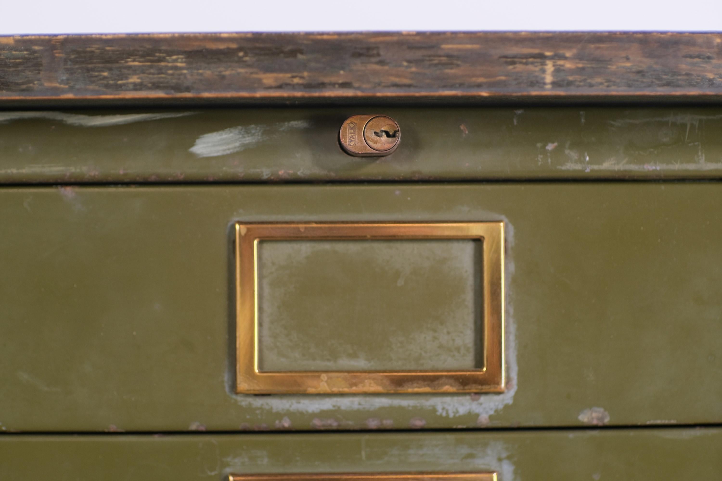 Early 20th Century stacking US Army green flat or map file cabinet. Comes with a well worn replacement wood top. Original brass hardware. This can be seen at our 1800 South Grand Ave location in Downtown LA.