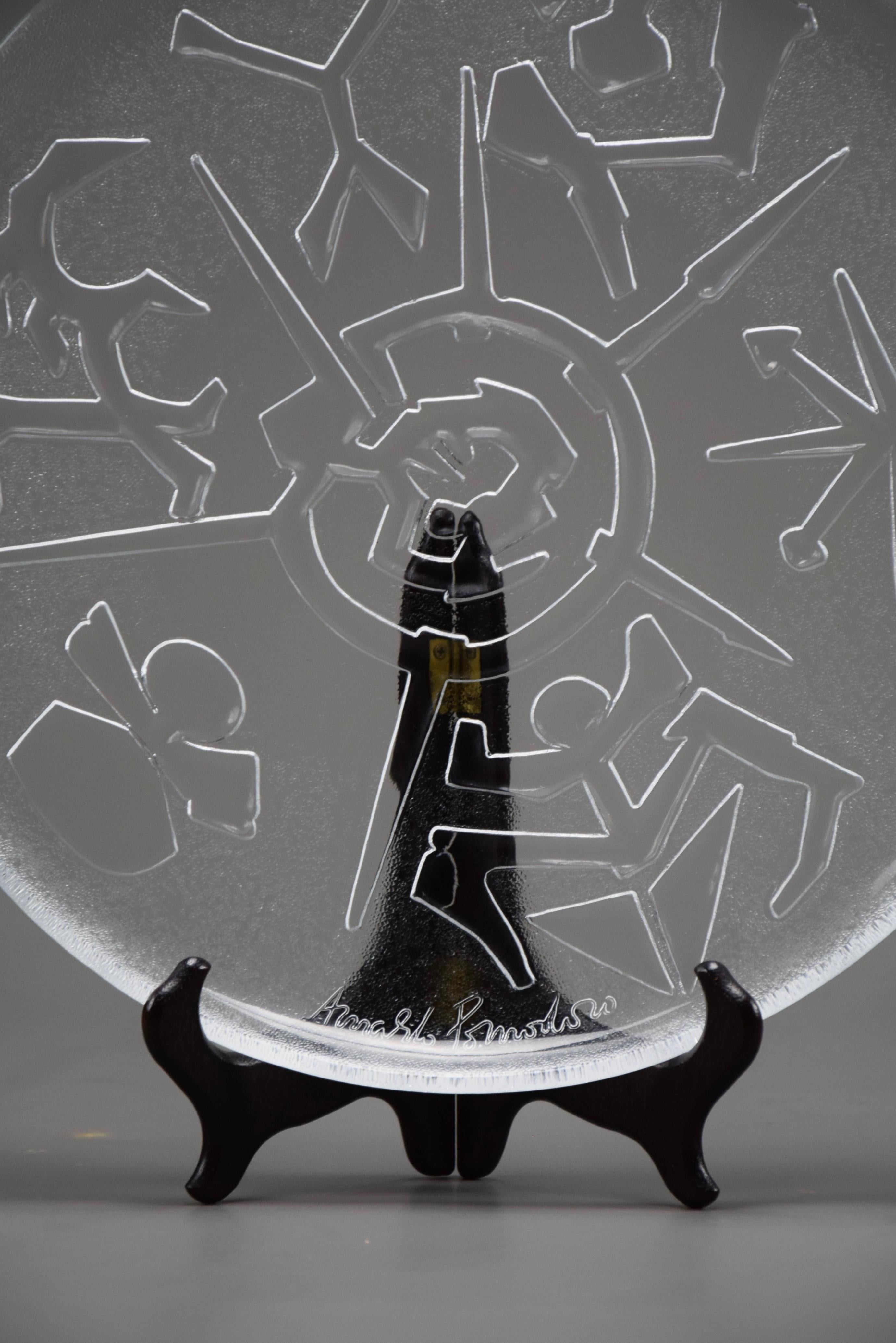 Questo raro e squisito piatto in vetro in edizione limitata è stato disegnato dal celebre artista italiano Arnaldo Pomodoro e prodotto da Ars D. A. Milano. Il pezzo, con un diametro di 32 cm, è realizzato in vetro sonoro di qualità superiore con
