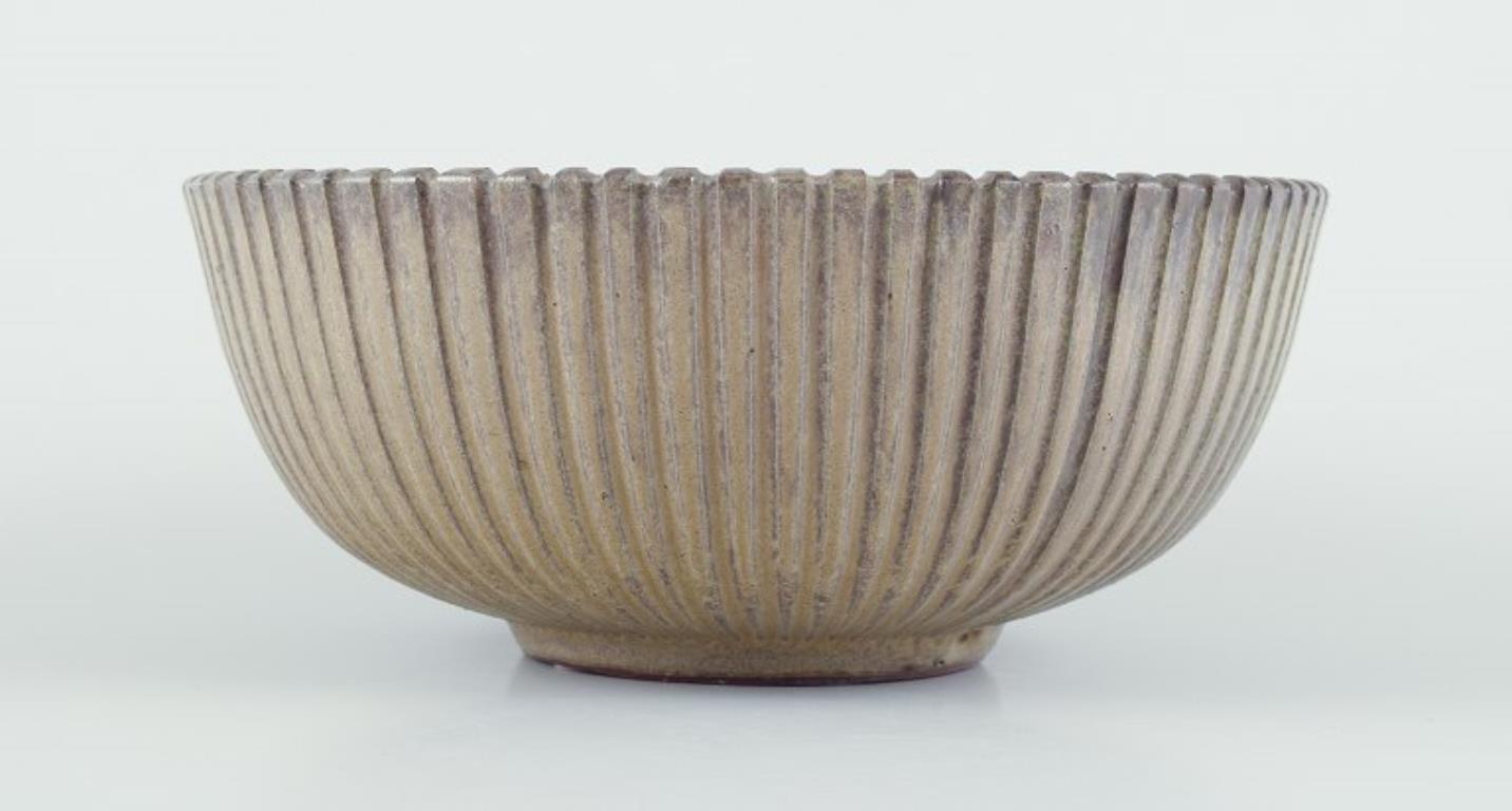 Arne Bang (1901-1983), Dänemark.
Schale aus glasierter Keramik, modelliert mit gerilltem Körper. 
Modellnummer 123. 
Schöne Glasur in hellen Brauntönen. 
1940er/50er Jahre.
In ausgezeichnetem Zustand. Kleine Blasen aus der Produktion. Siehe