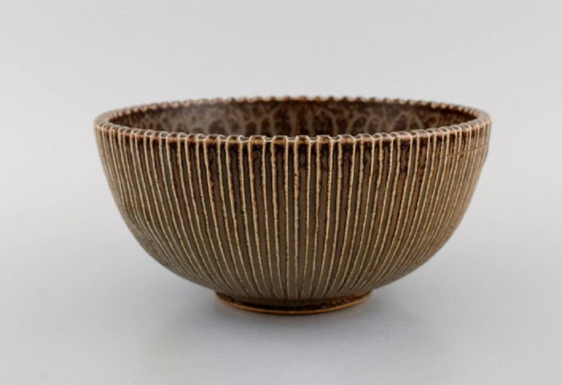 Arne Bang (1901-1983), Denmark. Bowl in glazed ceramics with the grooved body. Model number 122. 
Beautiful glaze in light brown shades. 
1940s / 50s.
Measures: 22 x 10.5 cm.
In excellent condition. Small crack in the bottom and bulge from the