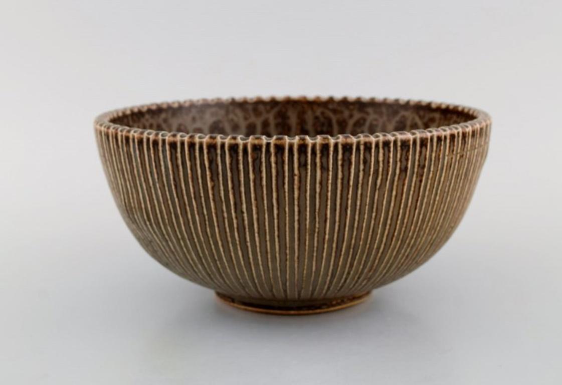Arne Bang (1901-1983), Denmark. 
Bowl in glazed ceramics modelled with the grooved body. 
Model number 122. 
Beautiful glaze in light brown shades. 
1940s / 50s.
Measures: 22 x 10.5 cm.
In excellent condition. Small crack in the bottom and bulge