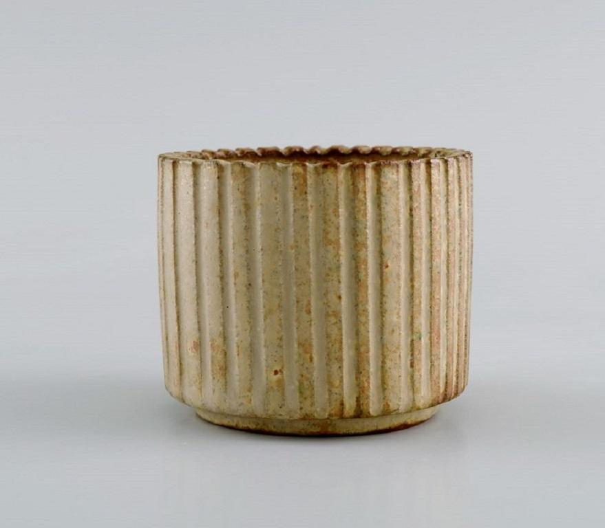 Arne Bang (1901-1983), Denmark. 
Miniature bowl / vase in glazed ceramics. 
Fluted body and beautiful glaze in sand shades. 
Mid-20th century
Measures: 7 x 6 cm.
In excellent condition.
Signed.