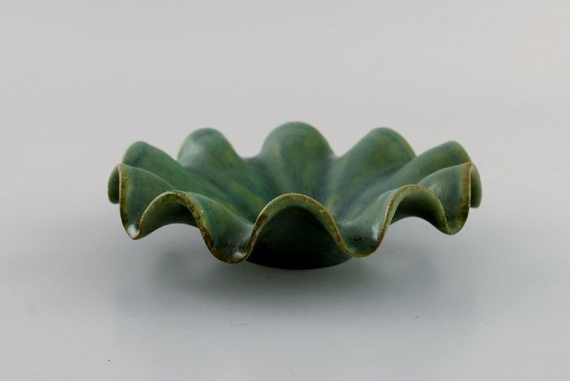 Arne Bang (1901-1983), Denmark. Bowl with wavy edge in glazed ceramics. 
Model number 151. Beautiful glaze in shades of green. 1940s.
Measures: 14 x 4 cm.
In excellent condition.
Signed in monogram.