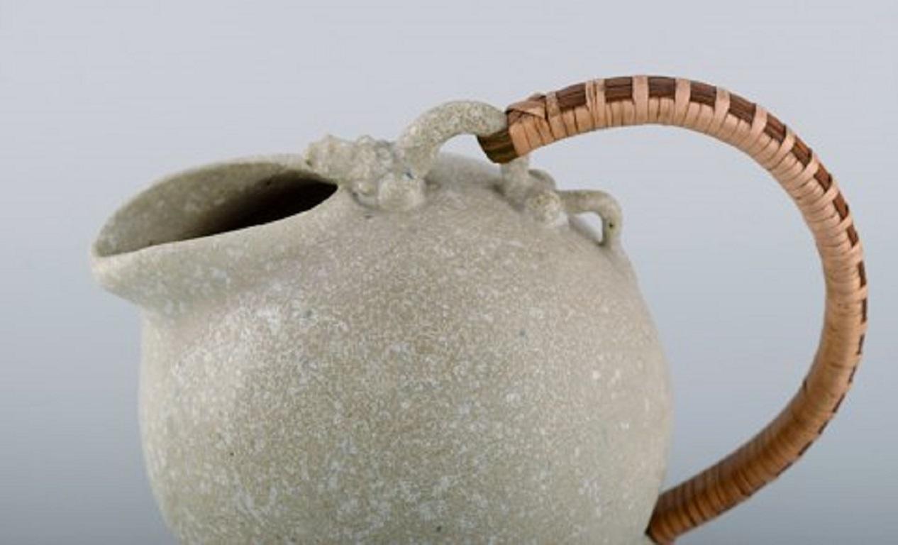 Arne Bang (1901-1983), Denmark. Jug in glazed ceramics with handle in wicker. Model number 151.
Beautiful speckled glaze in sand shades. 1940s / 50s.
Measures: 18.5 x 15.5 cm (incl. Handle).
In excellent condition.
Signed.