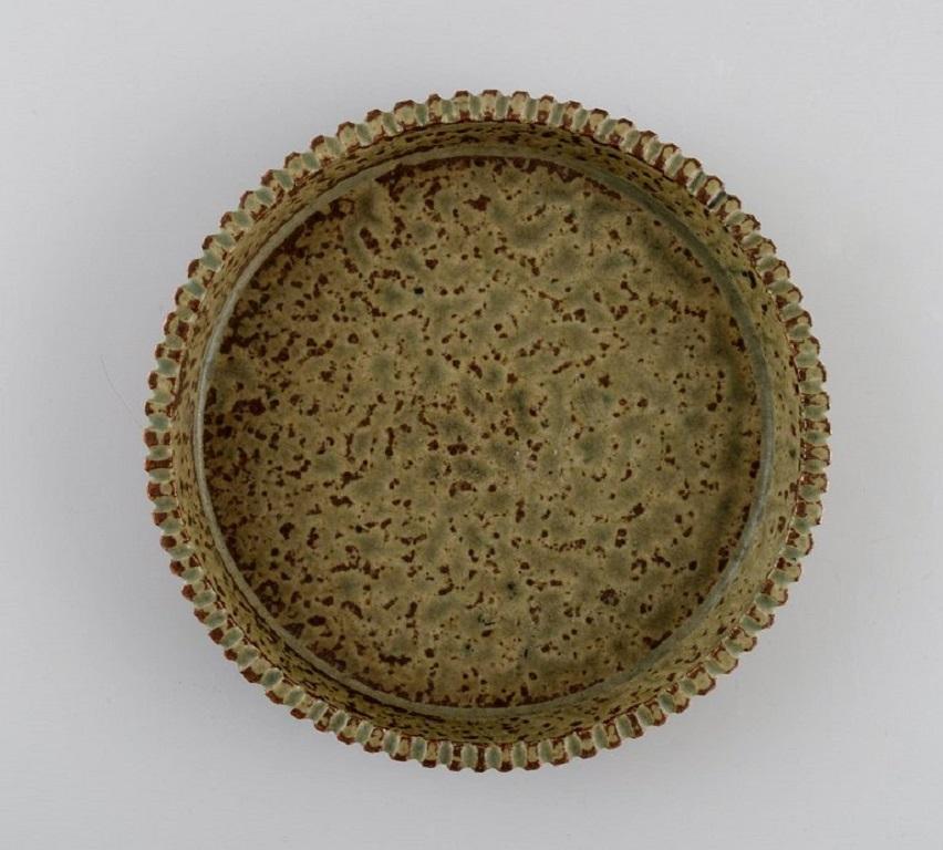 Arne Bang (1901-1983), Denmark. Low bowl with fluted edge in glazed ceramics. Beautiful speckled glaze in light earth shades. Mid-20th century.
Measures: 16 x 3 cm.
In excellent condition.
Signed in monogram.