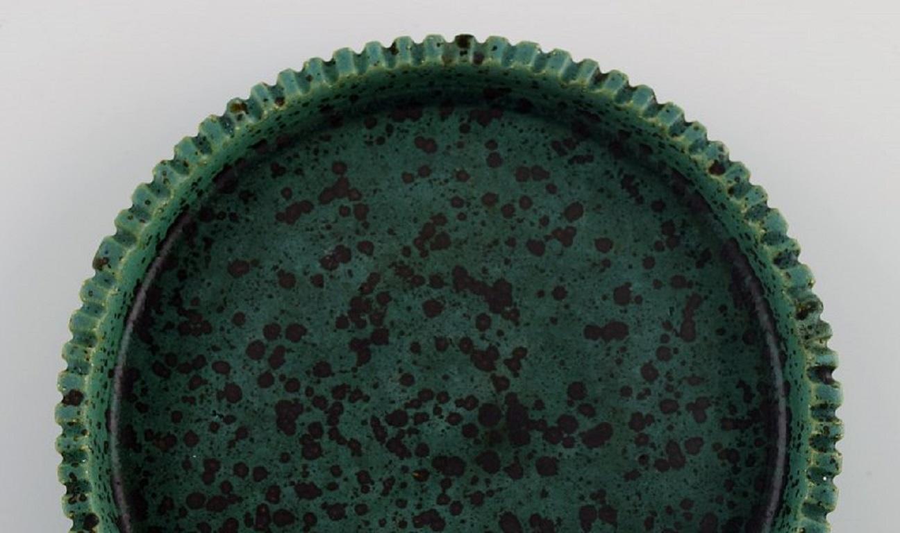 Arne Bang (1901-1983), Denmark. Round dish in glazed ceramics. 
Model number 127. Beautiful glaze in shades of green. 1940s.
Measures: 16 x 3 cm.
In excellent condition.
Signed in monogram.