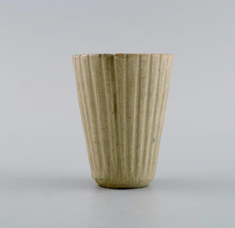 Arne Bang (1901-1983), Denmark. Vase in glazed ceramics. 
Fluted body and beautiful glaze in sand shades. Mid-20th century
Measures: 8 x 6,5 cm.
In excellent condition.
Signed.