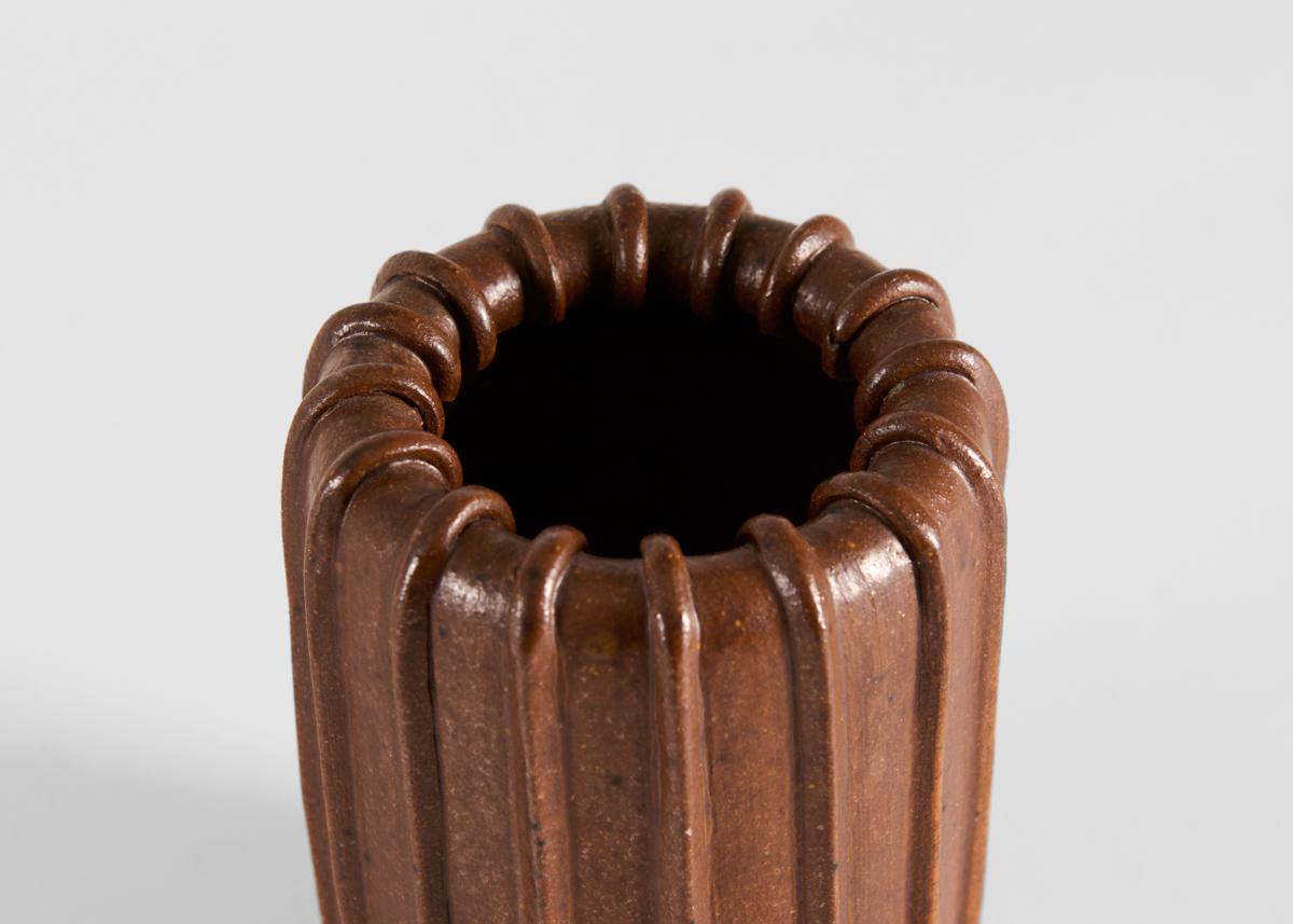 Questo piccolo vaso è a coste e riccamente smaltato in un marrone cioccolato-latte. Firmato.