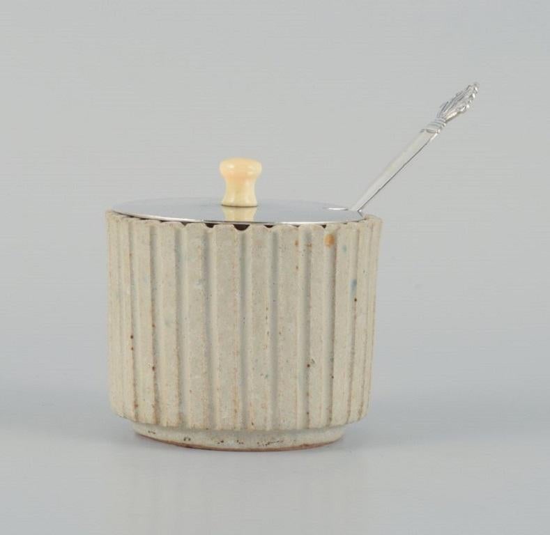 Arne Bang, ceramic honey jar in grooved design. Sand-colored glaze.
Model 128.
1940/1950s
Perfect condition.
Hand signed.
With matching Georg Jensen queen silver spoon and silver lid.
Measures: D 7.5 x H 7.5 cm.