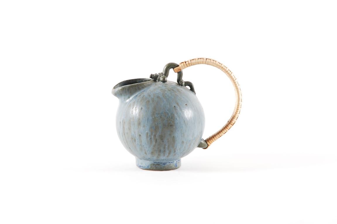 Danish ceramic stoneware by Arne Bang (1901-1983), circa 1950.
Jug in blue crystallized enamel with a rattan handle.
Signed by the ceramist Artist, monogram 