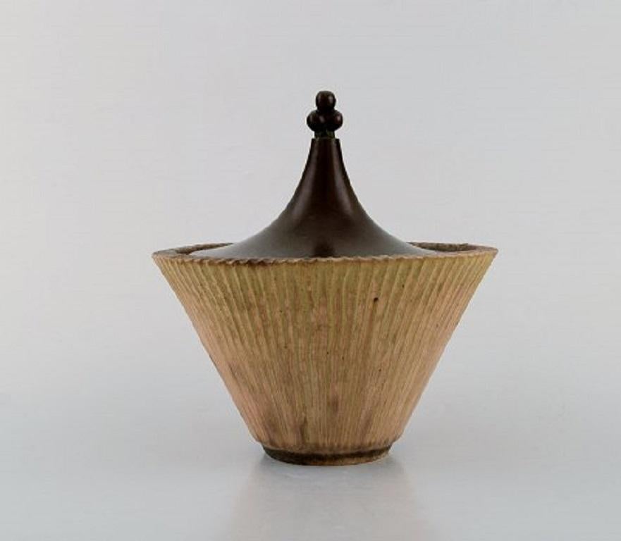 Arne Bang, Denmark. Glazed ceramic pot with bronze lid. Beautiful glaze in light earth tones, 1940s.
Stamped: AB 119.
In perfect condition.
Measures: 15.5 x 14.5 cm.

 