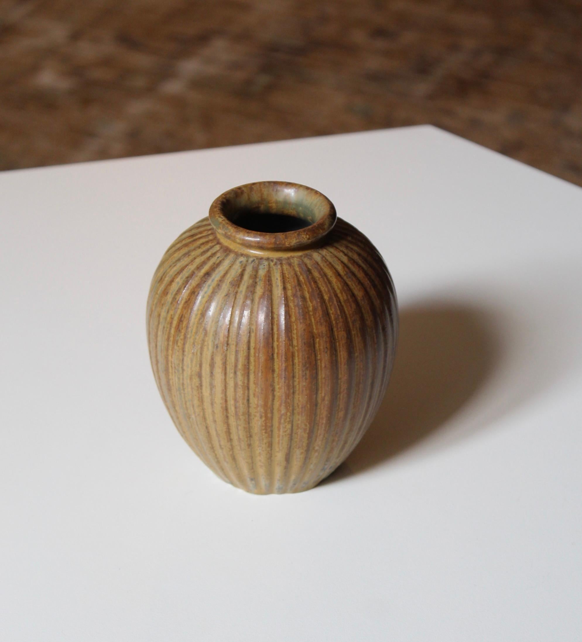 A brown-glazed fluted stoneware vase designed and produced by Arne Bang, Denmark, 1940s. 


