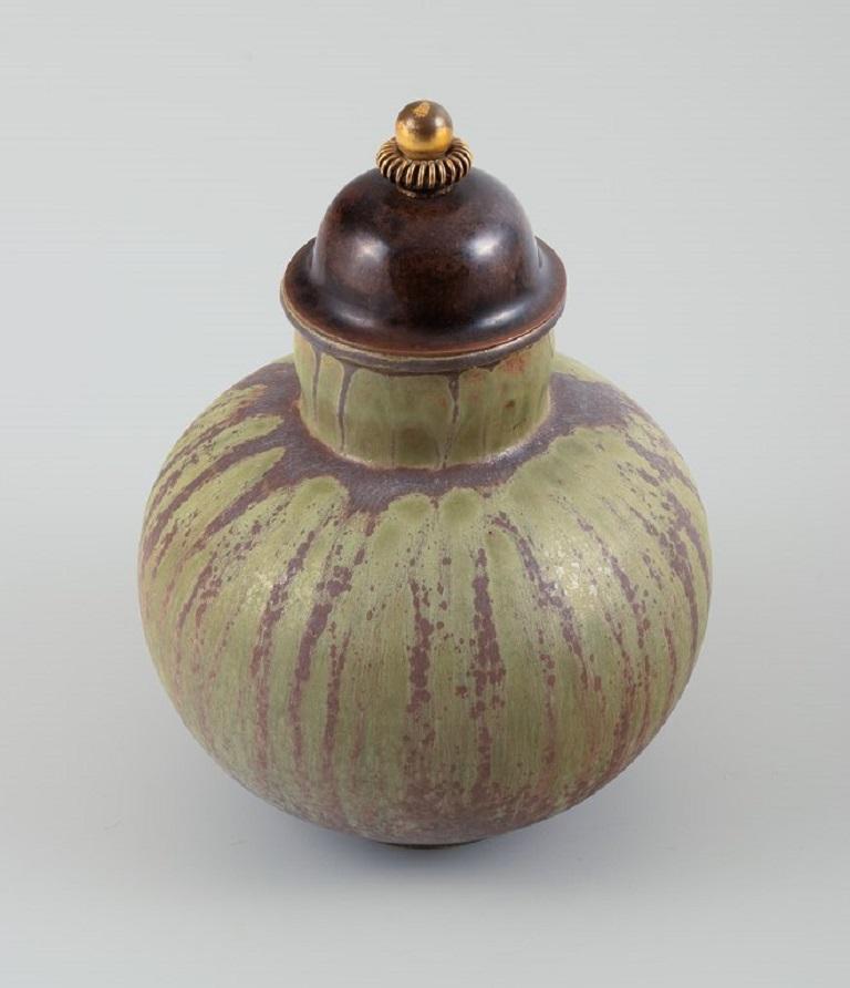 Arne Bang for Holmegaard. Round Art Deco lidded vase in glazed ceramic with bronze lid. Beautiful glaze in brown-green shades.
Dated 1944.
Measurements: H 21 cm. x D 16 cm.
In excellent condition.
Signed.