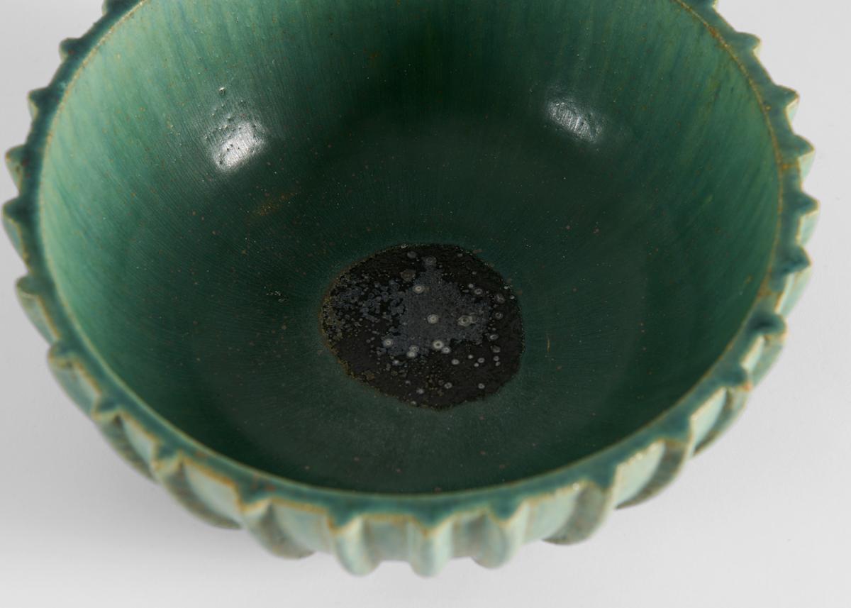 This large bowl is ribbed and richly glazed in green. Signed and numbered 129.