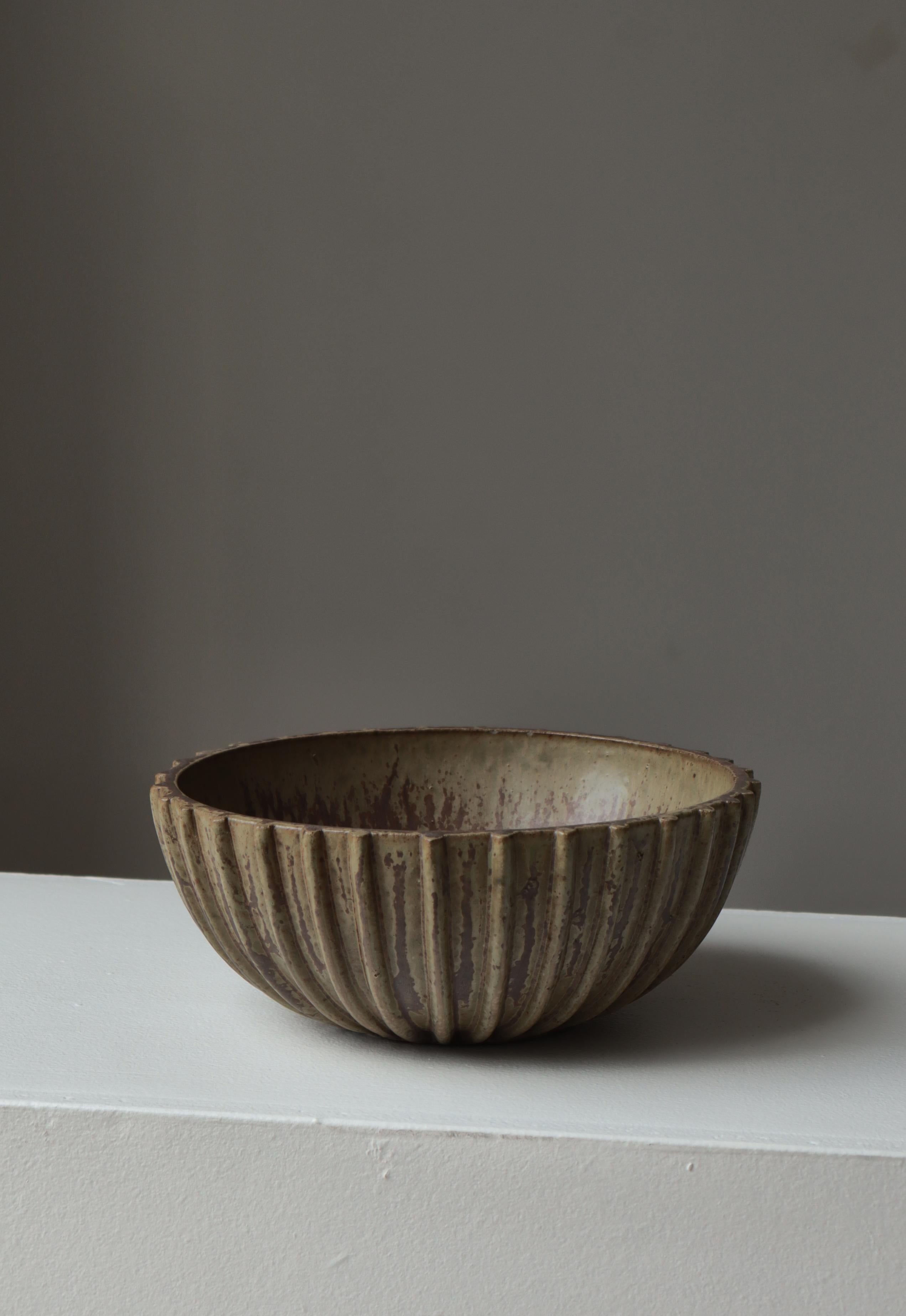 A classic stoneware bowl by renowned Danish ceramicist Arne Bang, model 189, showcasing his signature combination of sculptural form and subtly expressive glazing. This large bowl features a beautifully ribbed exterior, its vertical fluting creating