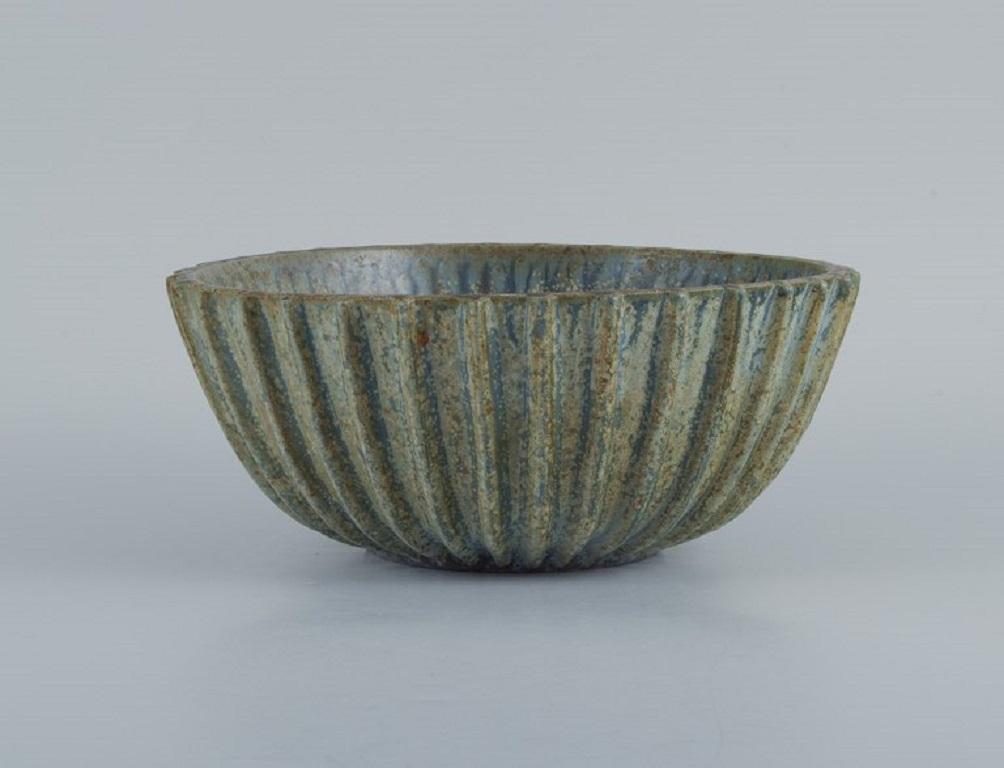 Arne Bang. Large stoneware table bowl with fluted body decorated with green mottled glaze.
1930s/1940s.
Signed in monogram. No. 189.
In perfect condition.
Dimensions: D 25.0 x H 10.0 cm.
