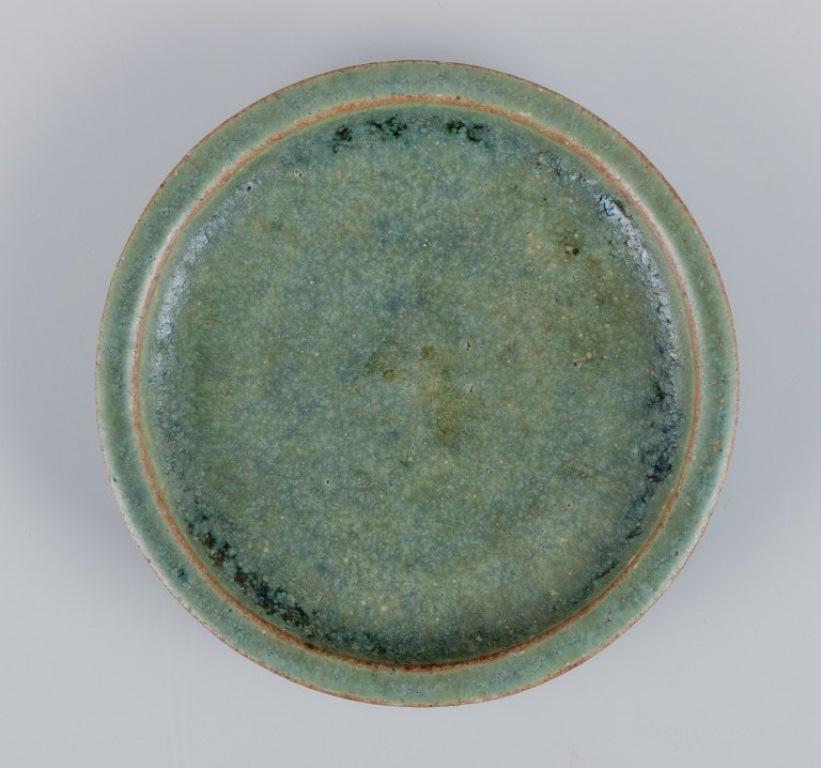 Arne Bang, own workshop. Small ceramic dish decorated in blue-green glaze. Handmade.
Model 167.
Mid-20th century.
Signed.
In excellent condition.
Dimensions: Diameter 8.0 cm x Height 1.6 cm.