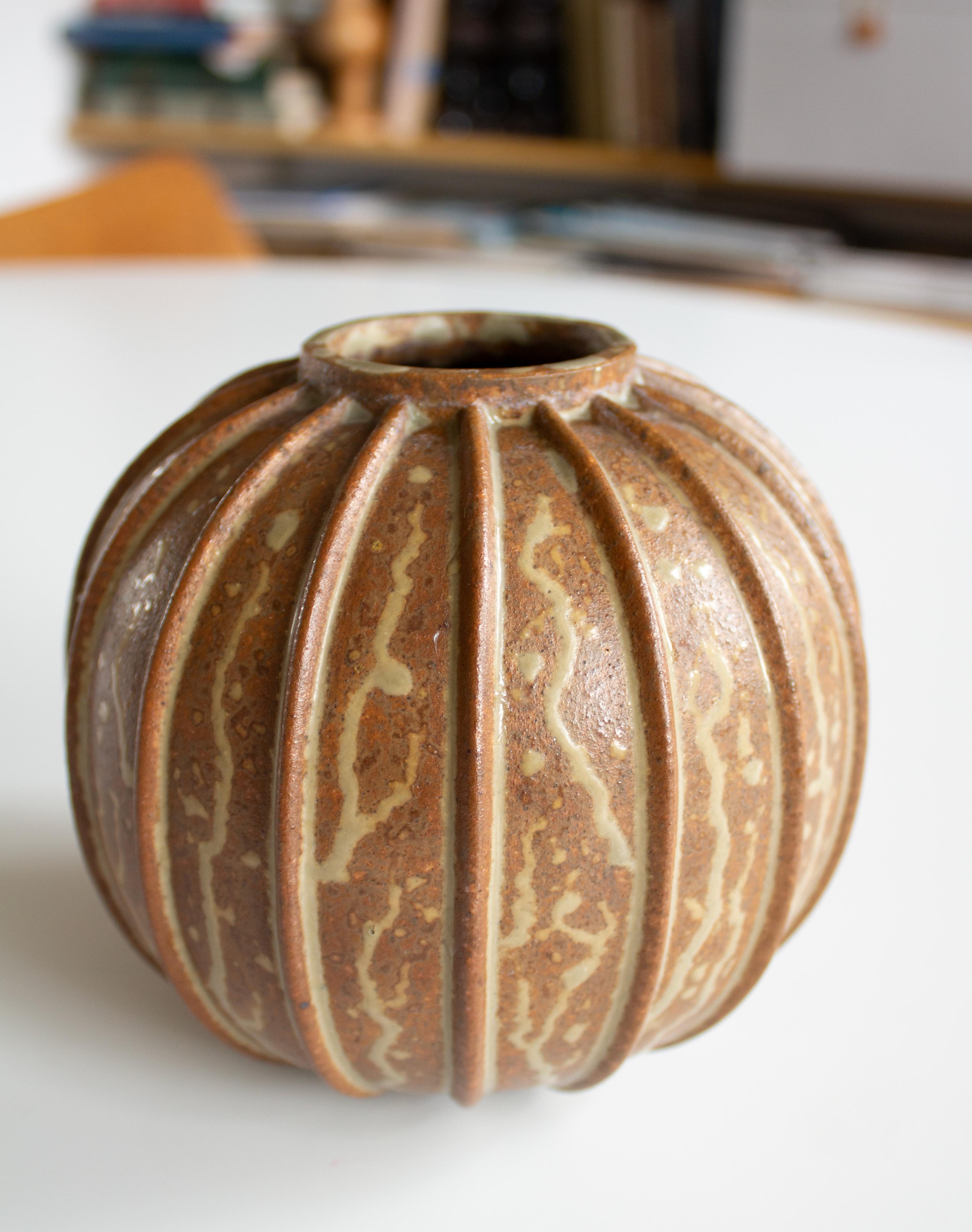 Vase en grès à nervures verticales, conçu par Arne Bang (1901-1983), l'un des plus éminents artistes céramistes danois du XXe siècle. La forme est audacieuse et architecturale, avec une forte présence sculpturale - une marque de fabrique de l'œuvre