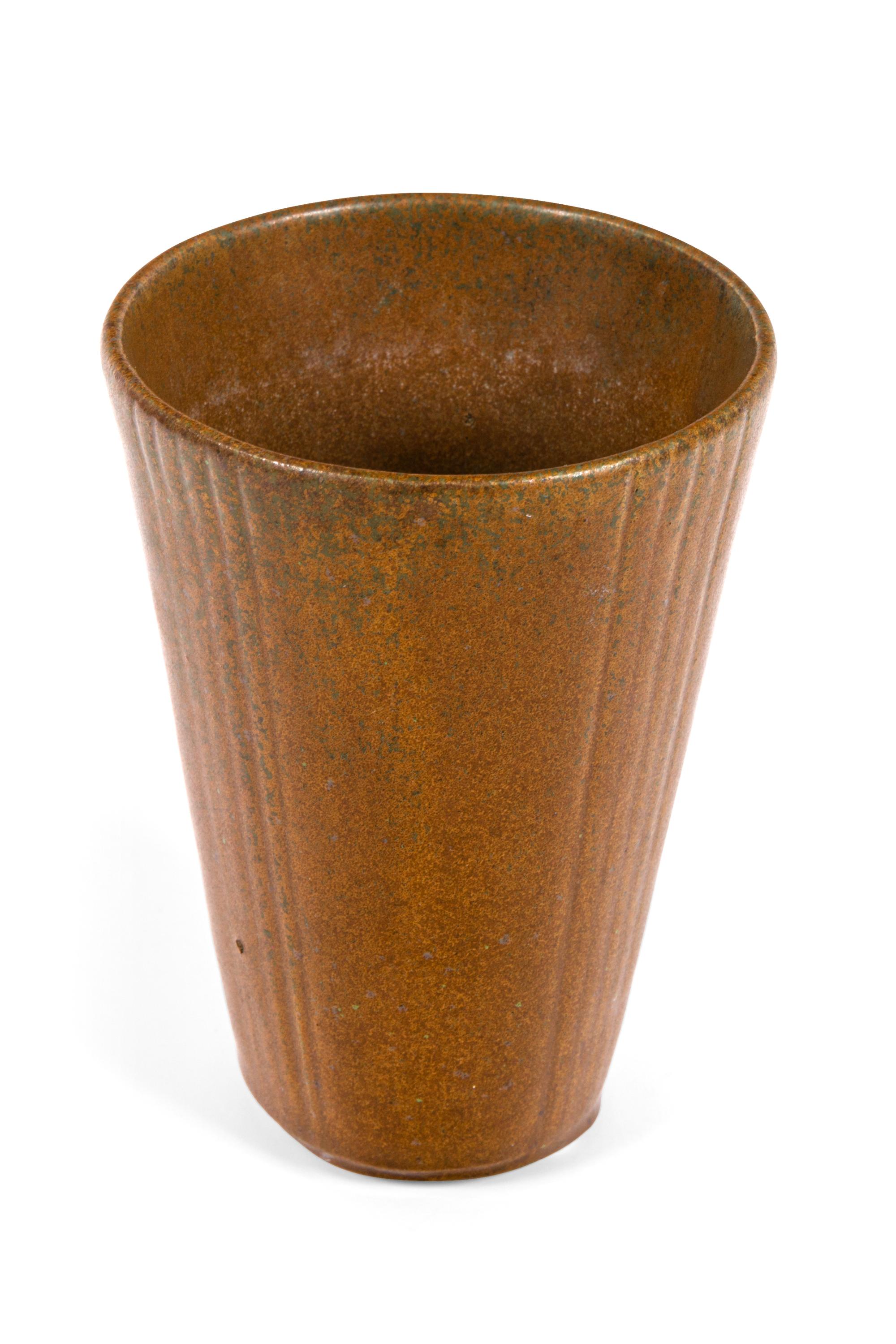 A very simple form enhanced by the added incised vertical lines running up four sides of the vase.