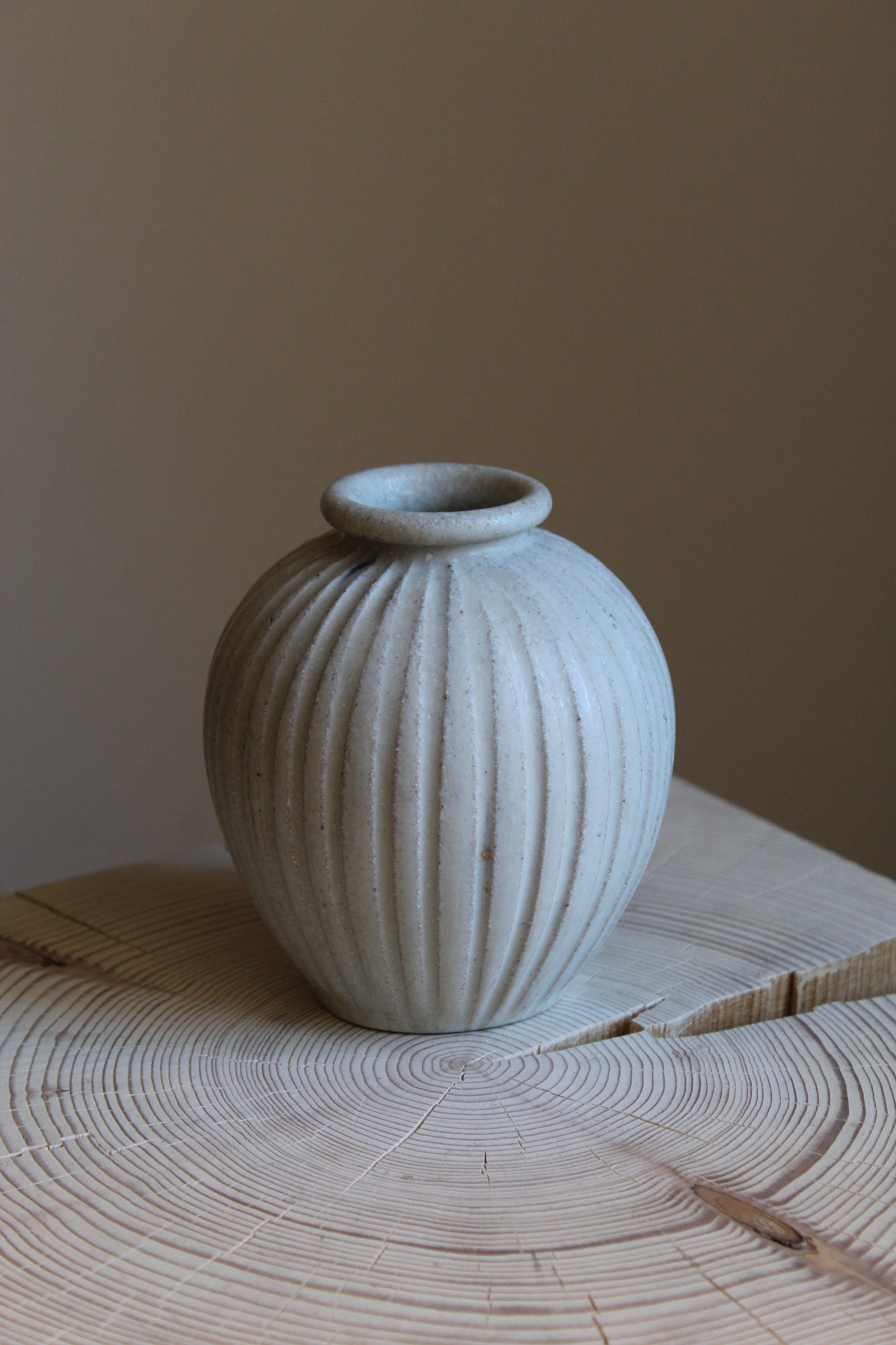 An early small vase. Designed by Arne Bang, produced c. 1927. Light-grey glazed stoneware. Features ornamental ridges iconic to Bangs production.

Other designers of the period include Axel Salto, Wilhelm Kåge, Gunnar Nylund, Berndt Friberg, and